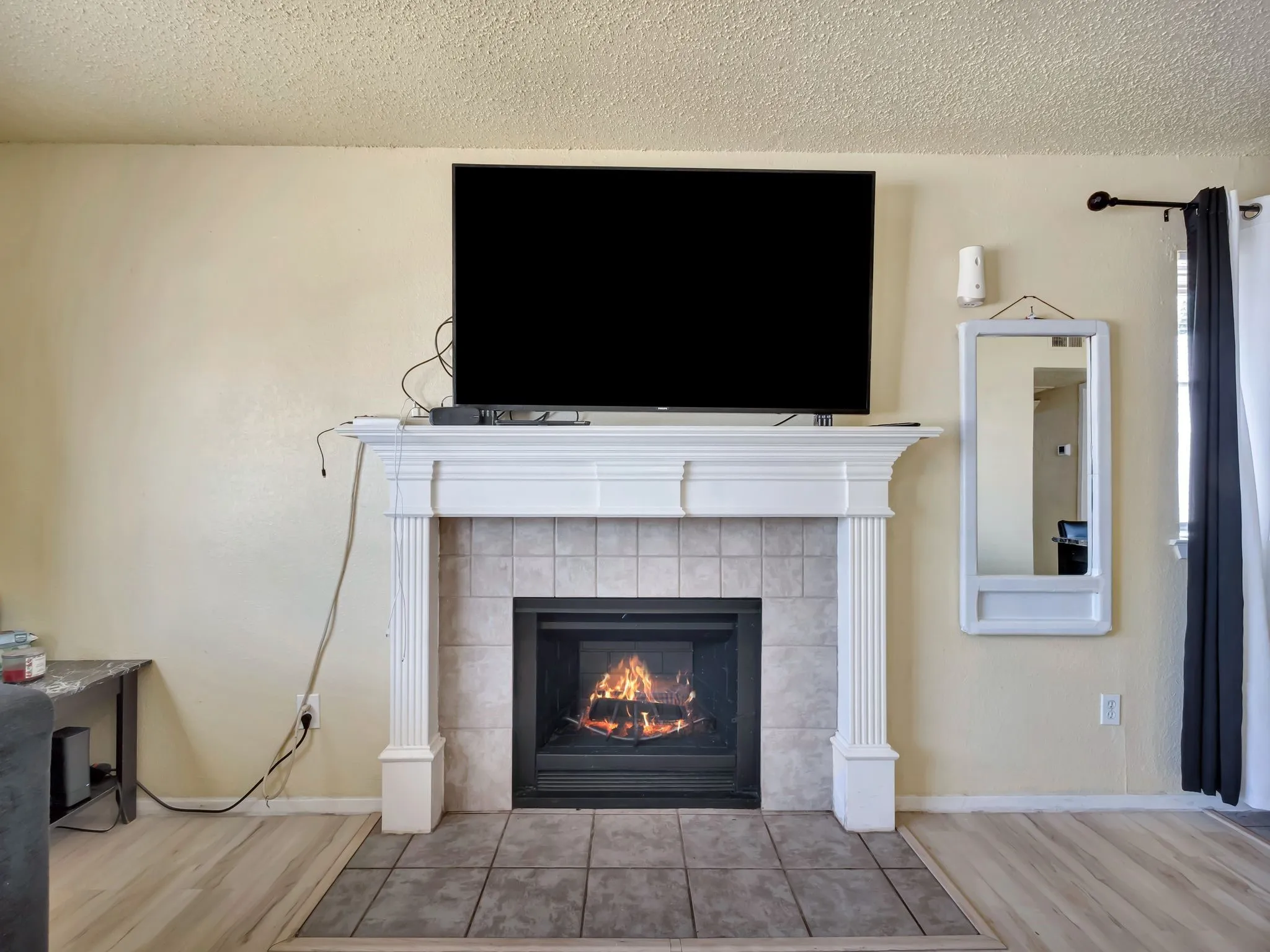 Detailed view of wood finished floors, a tile fireplace, and a textured ceiling