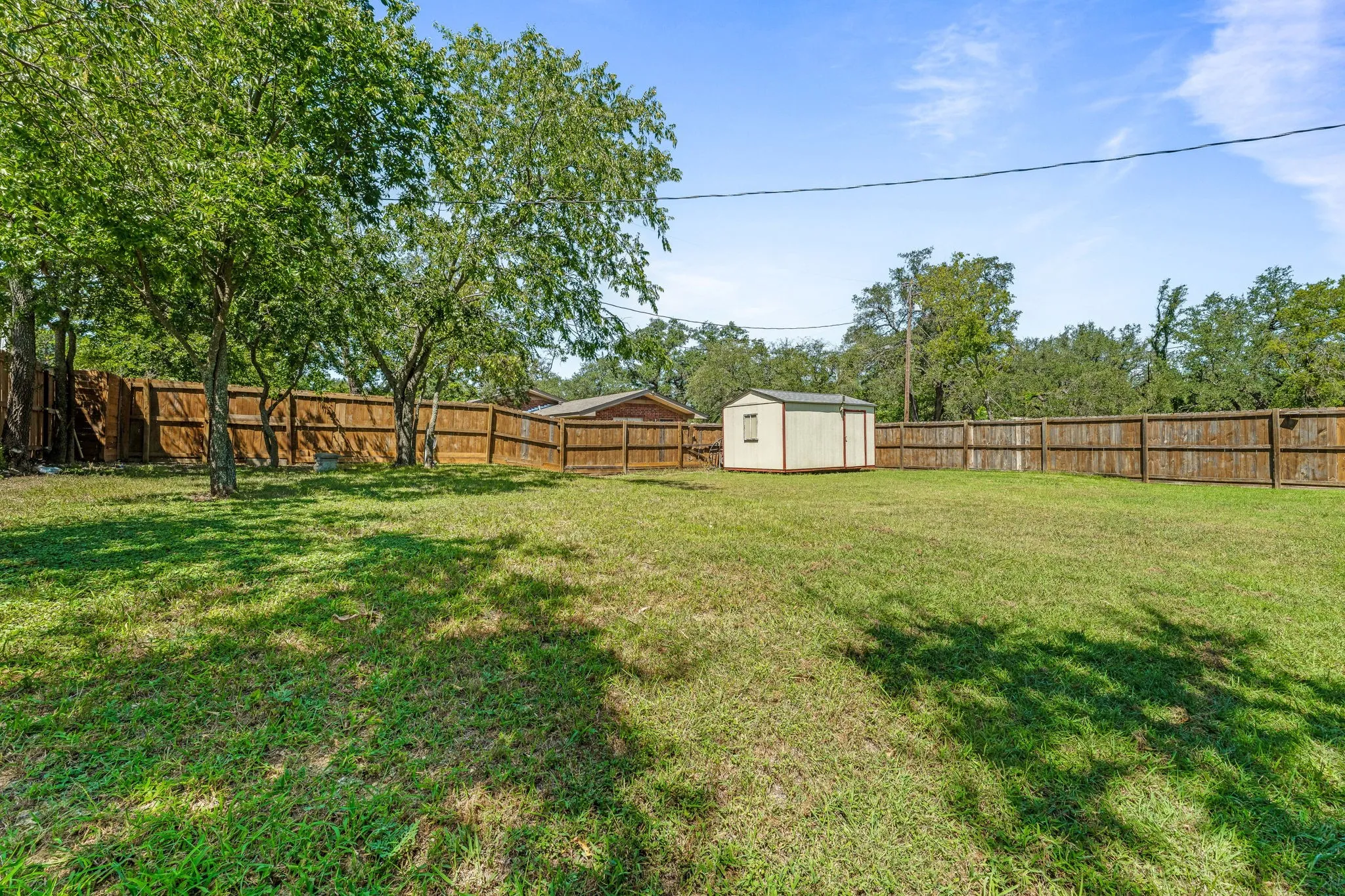 Fenced backyard with a storage unit