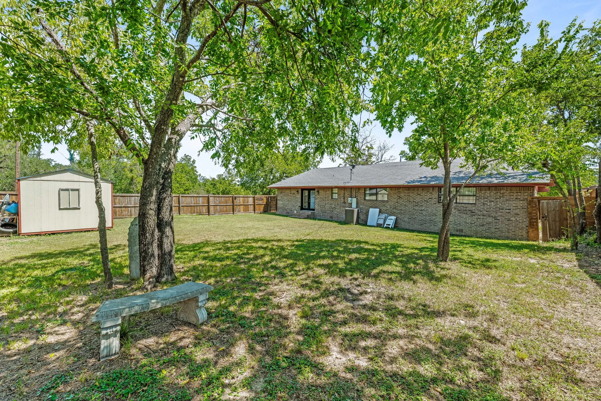 Fenced backyard with a storage unit