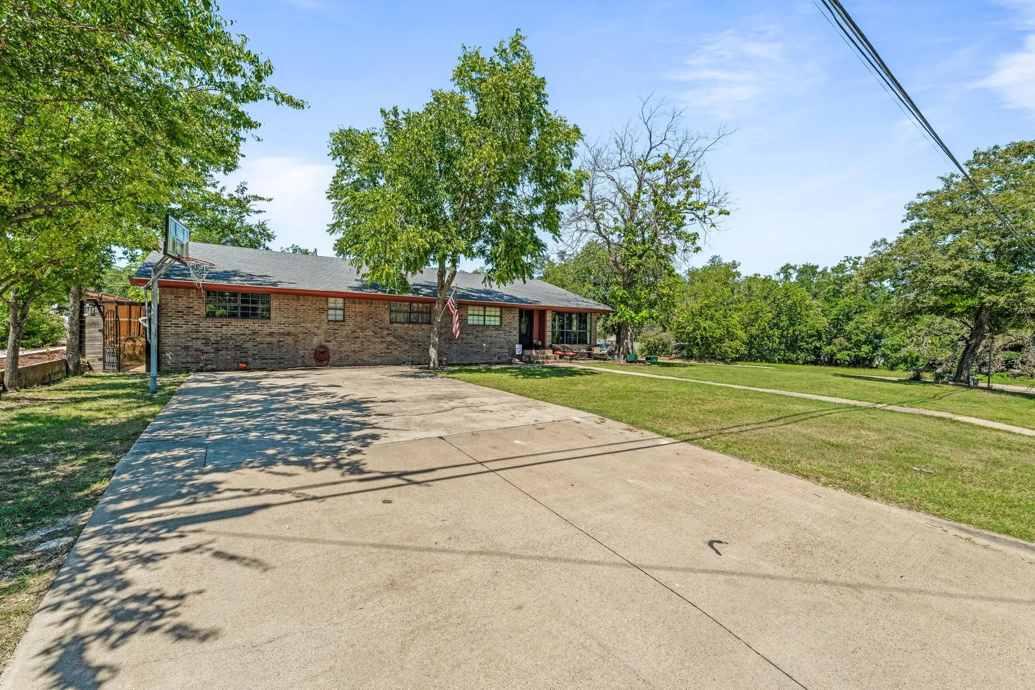 Ranch-style house with concrete driveway and brick siding