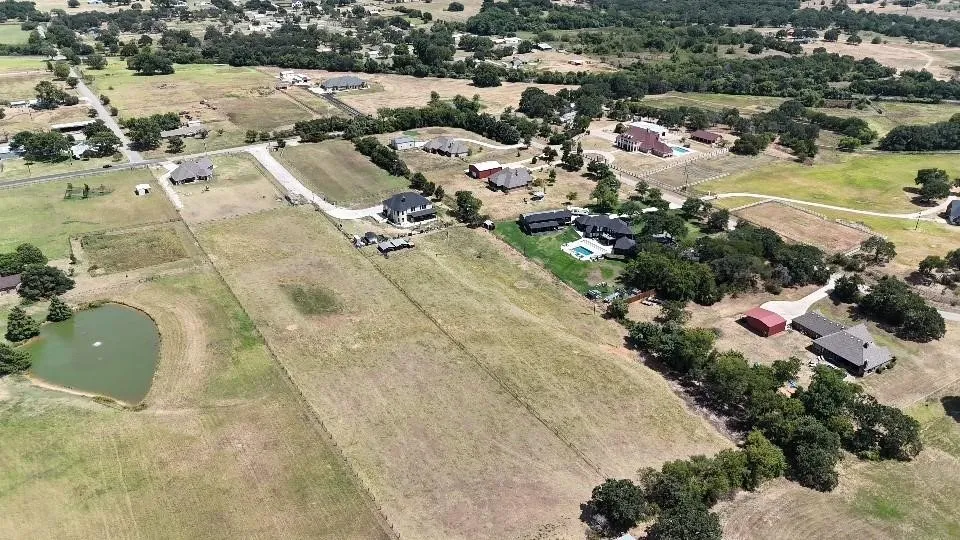Aerial view of property and surrounding area with a large body of water and rural landscape