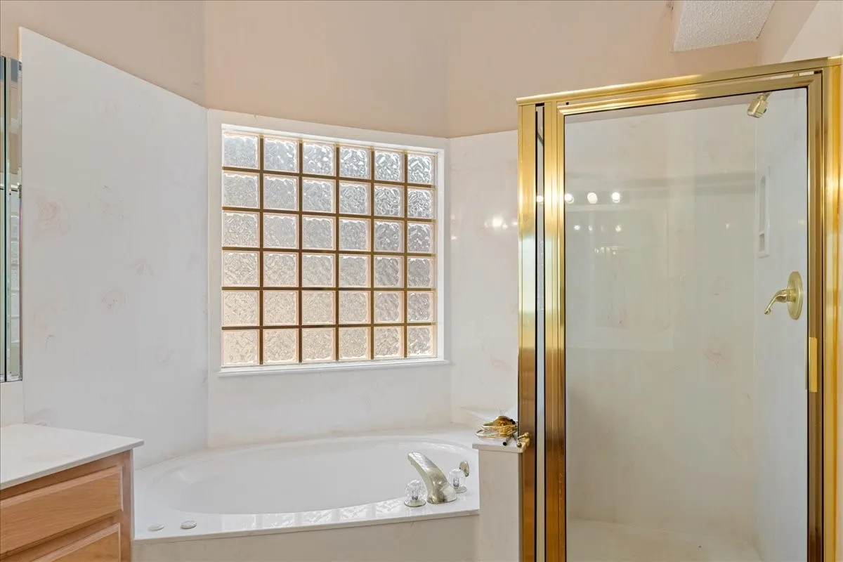 Bathroom featuring vanity, a bath, and a shower stall