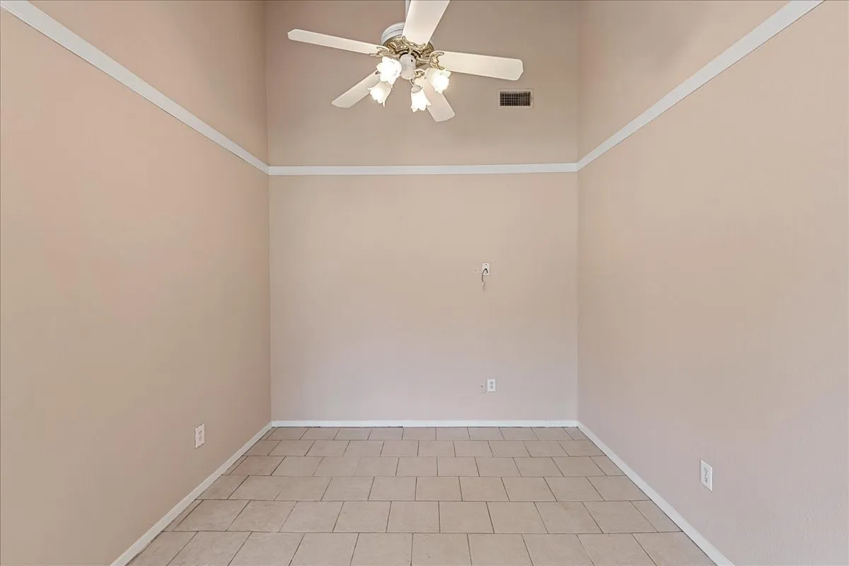 Spare room featuring a ceiling fan and light tile patterned floors