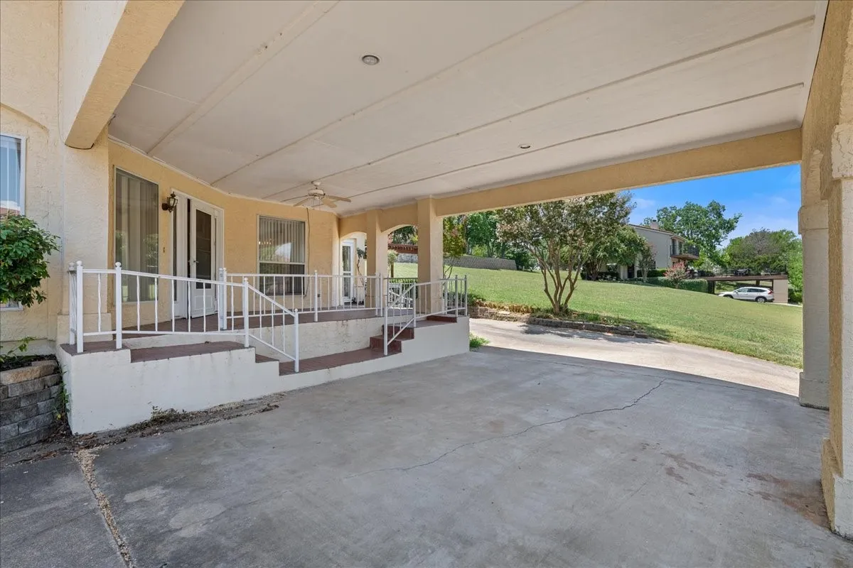 Covered porch with a lawn, ceiling fan, and a patio