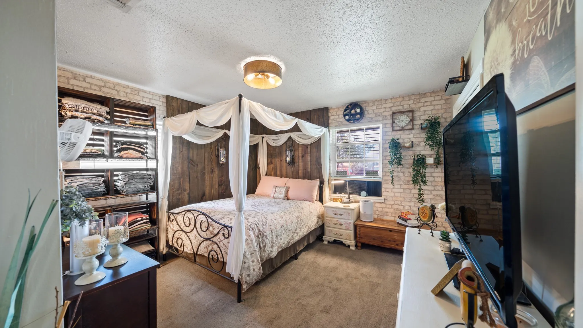 Exposed brick-finish accent wall, wood-finish paneling, and a drum-style ceiling light fixture