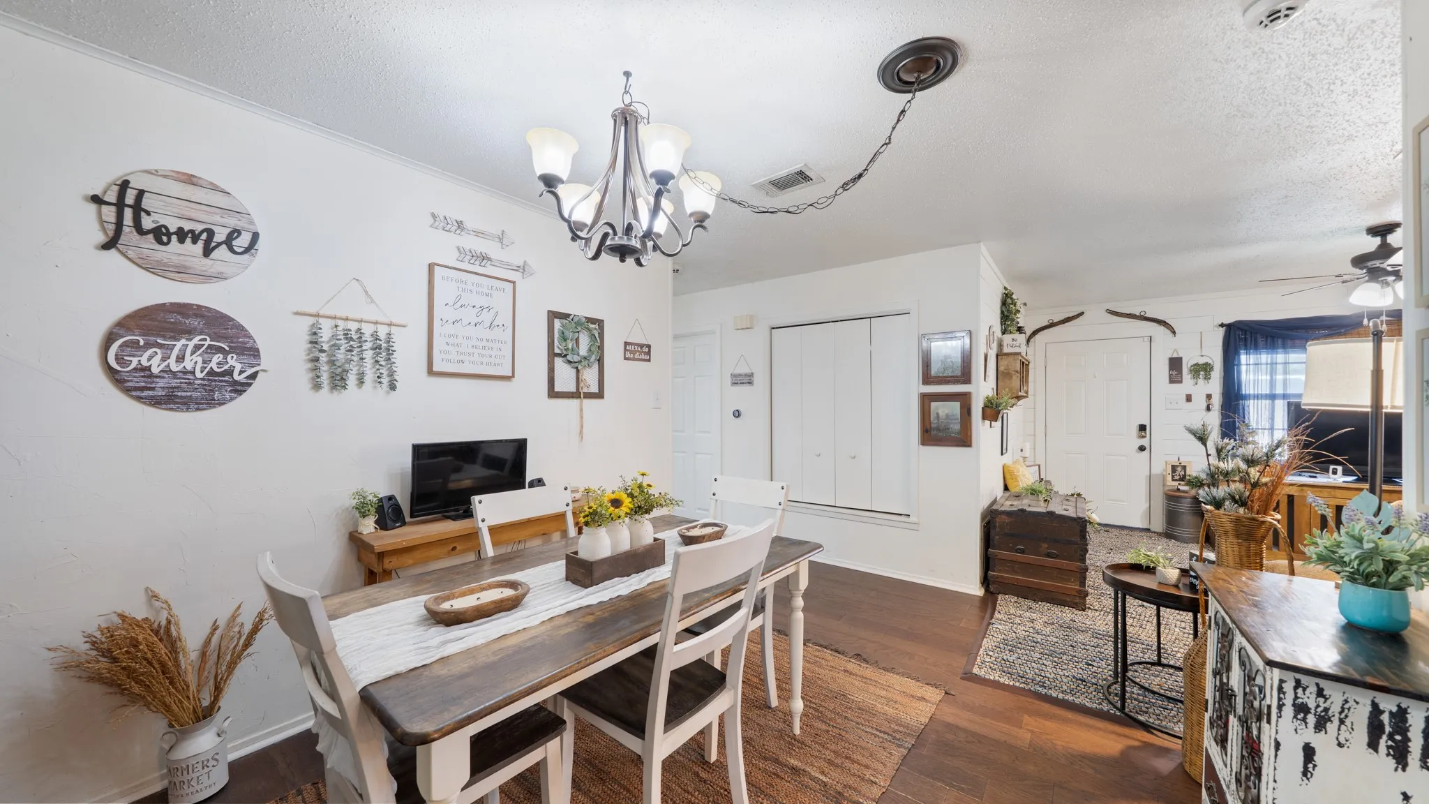 Expansive room featuring wood-finish flooring, a multi-light chandelier, and white wall finishes