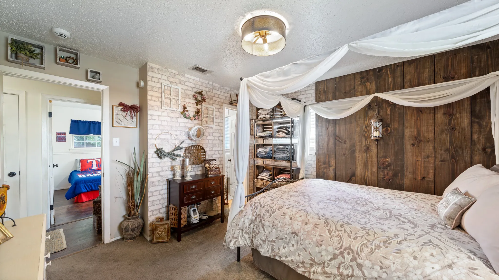 Shiplap accent wall, exposed brick texture, ceiling-mounted lighting fixture, and a built-in shelving unit
