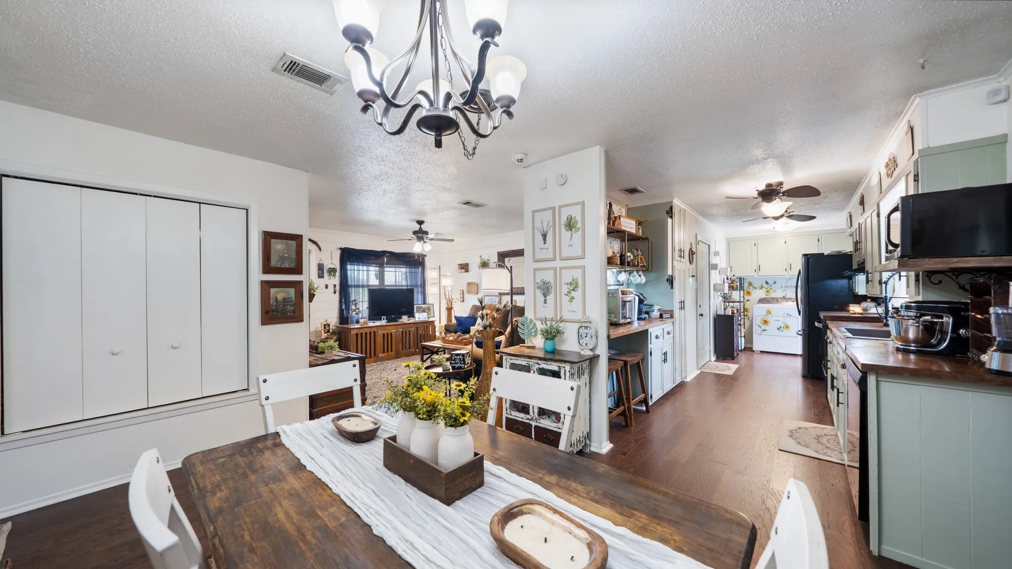 Dining space with wood-finish flooring, a decorative chandelier, and white bifold doors
