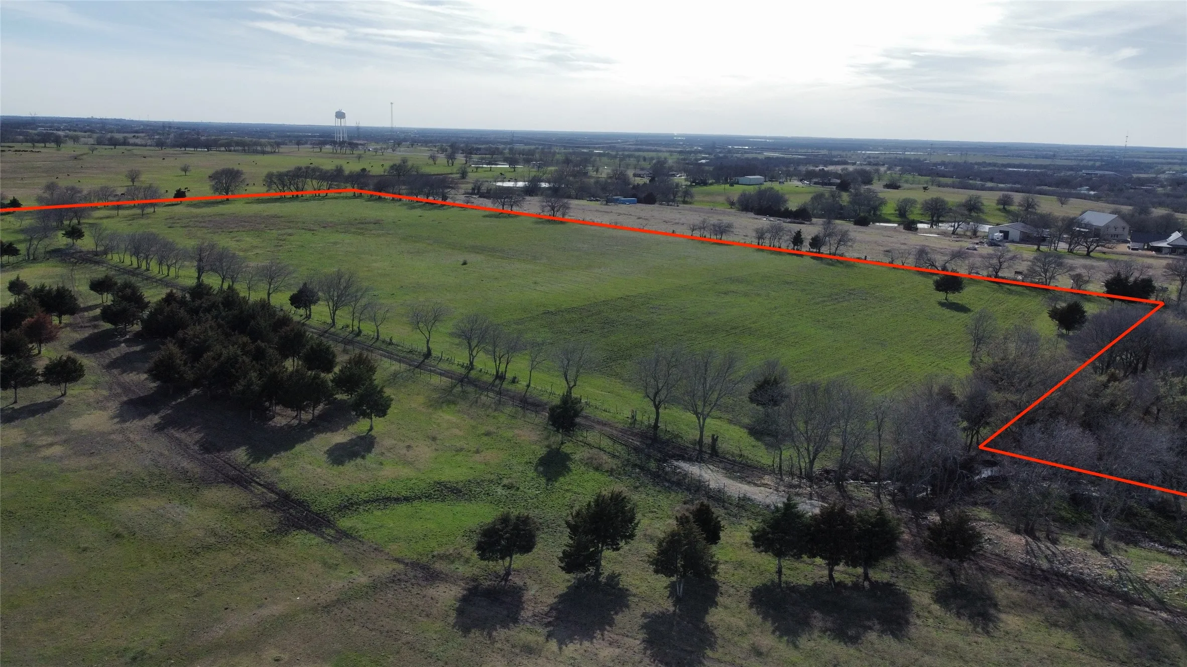 Aerial view of sparsely populated area featuring property parcel outlined and a pastoral area