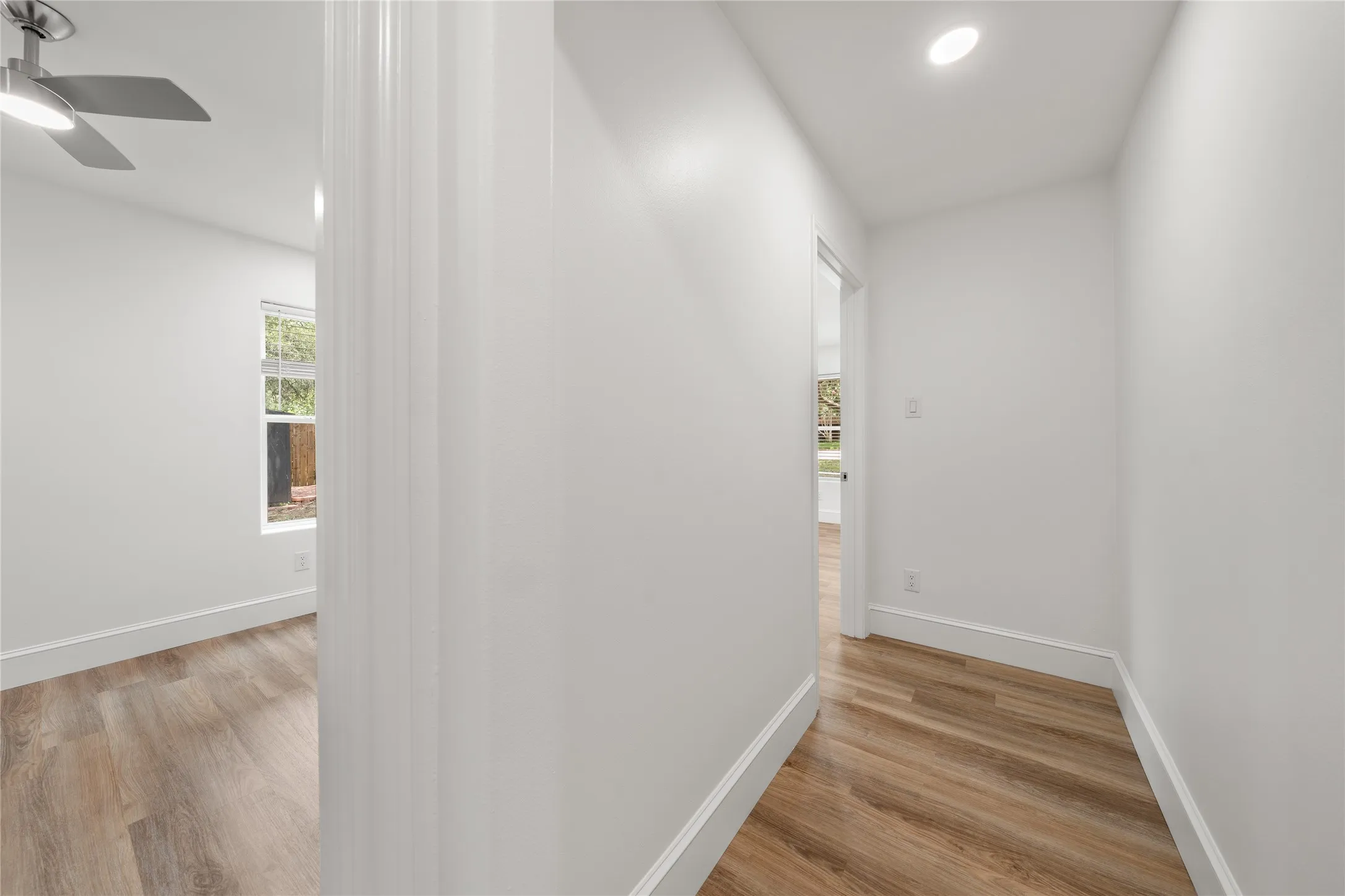 Corridor with light wood-style floors and recessed lighting