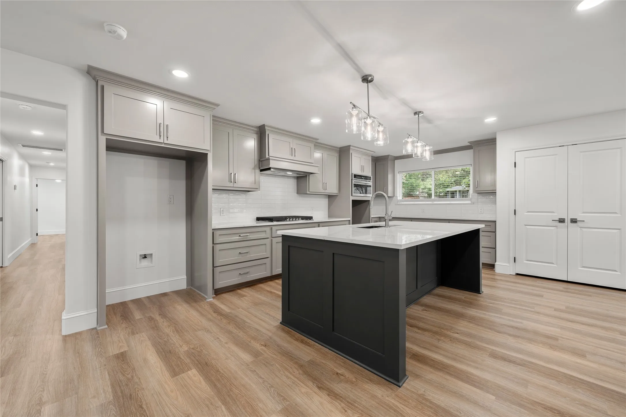 Kitchen featuring gray cabinets, tasteful backsplash, recessed lighting, light countertops, and light wood finished floors