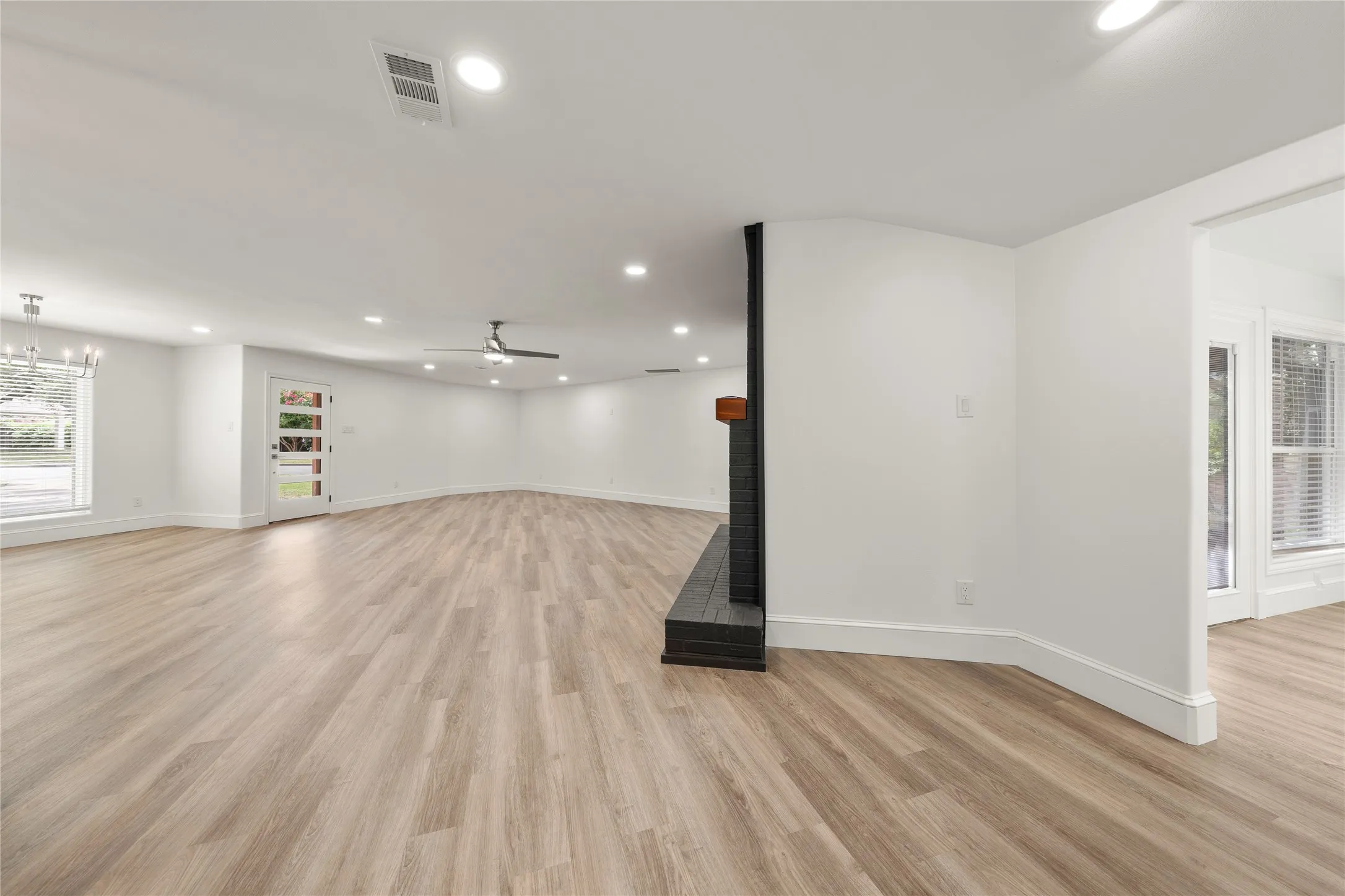 Below grade area with recessed lighting, a multi sided fireplace, light wood-style floors, and ceiling fan