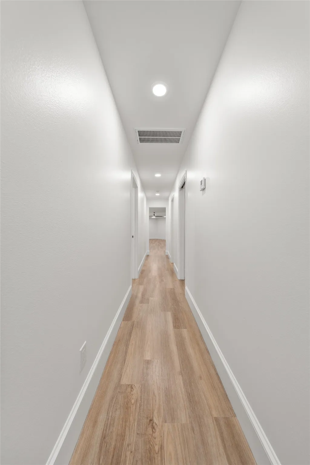 Corridor featuring light wood-style flooring and recessed lighting