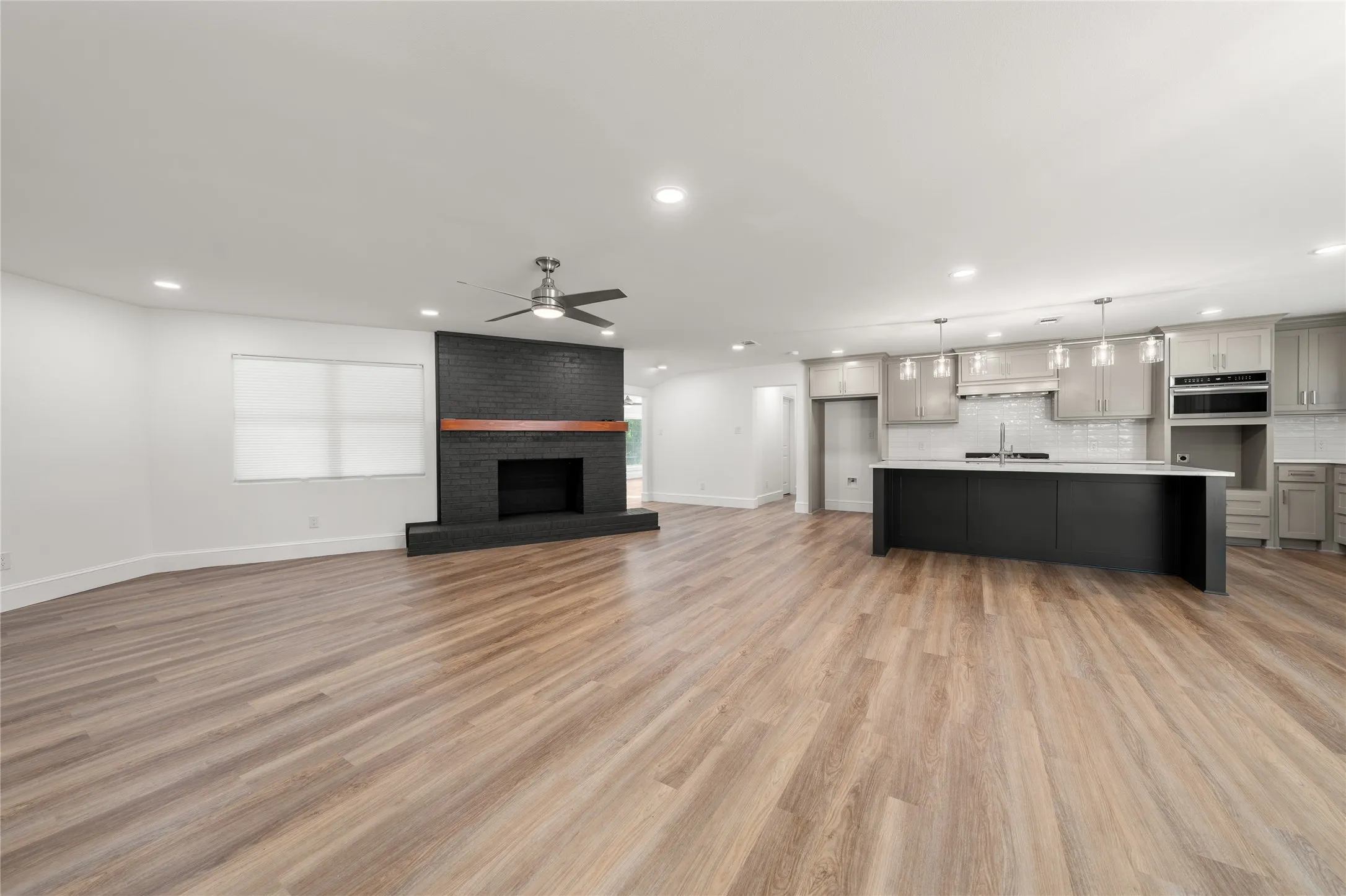 Unfurnished living room with light wood-style floors, recessed lighting, ceiling fan, and a fireplace