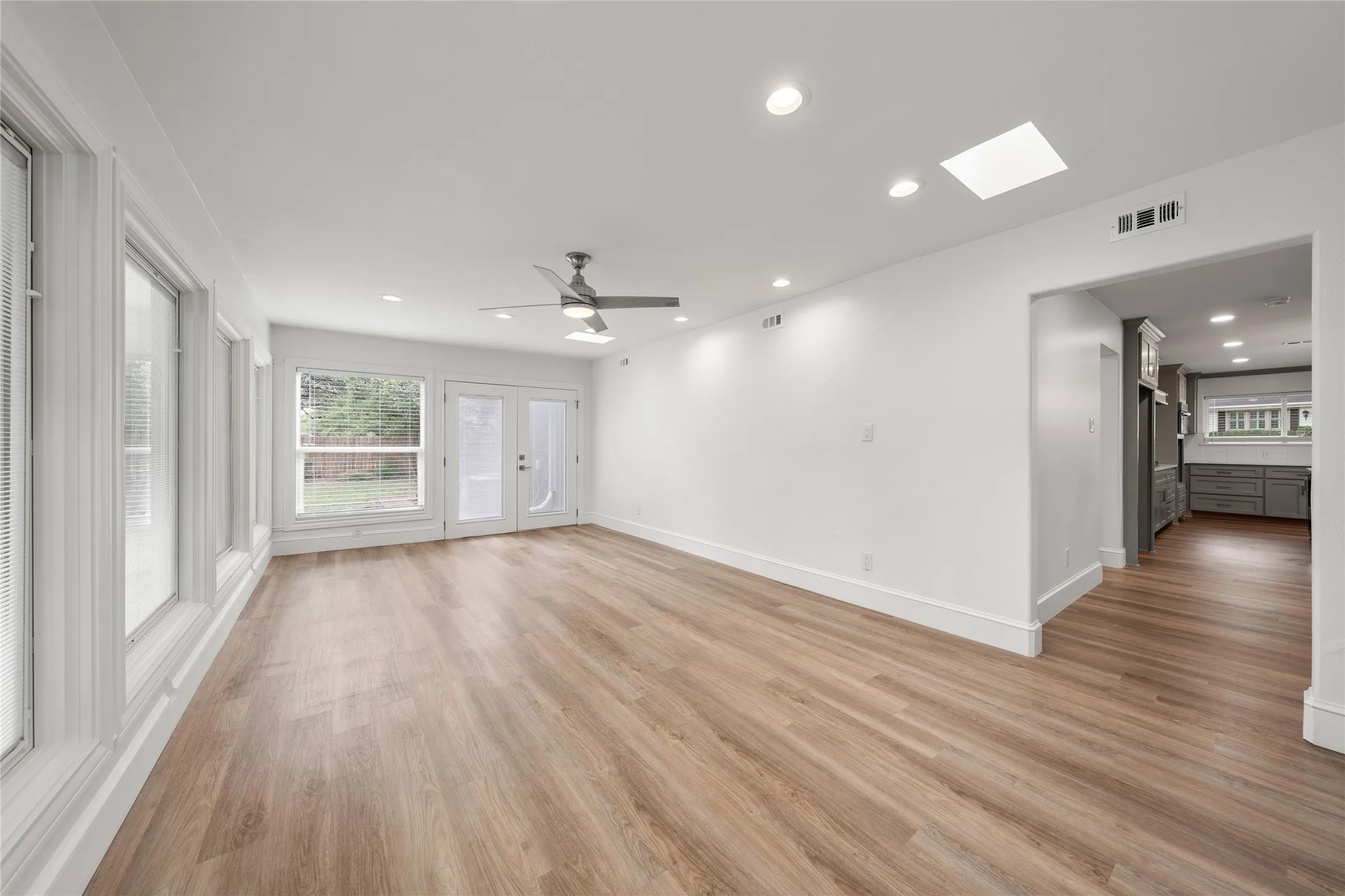 Unfurnished living room featuring plenty of natural light, light wood-style floors, recessed lighting, and a ceiling fan