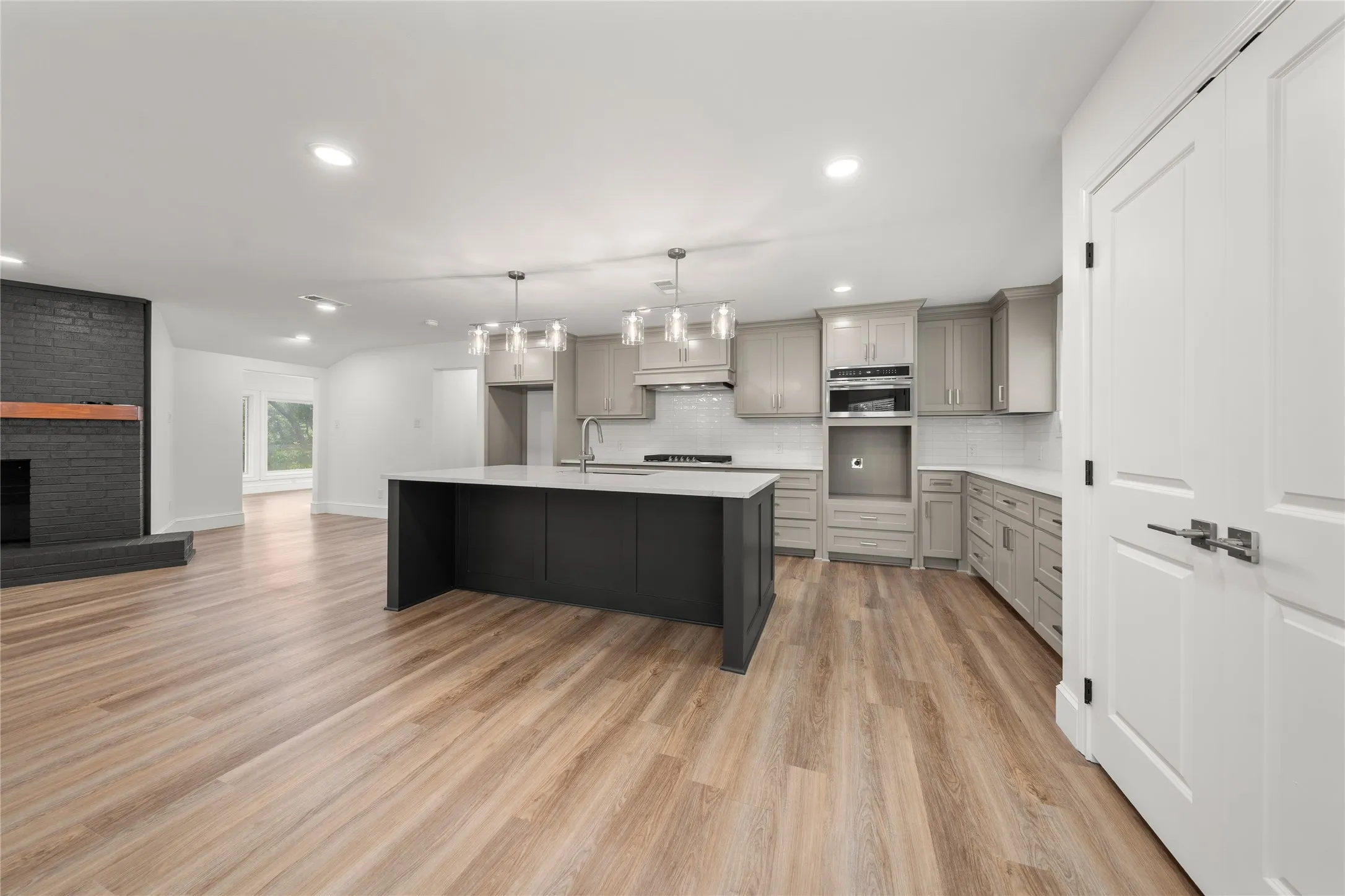 Kitchen featuring gray cabinets, light wood-style floors, light countertops, recessed lighting, and backsplash