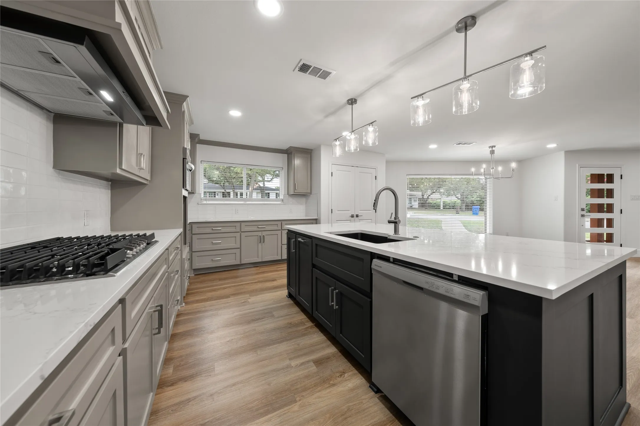 Kitchen with extractor fan, stainless steel appliances, plenty of natural light, light wood-style flooring, and recessed lighting