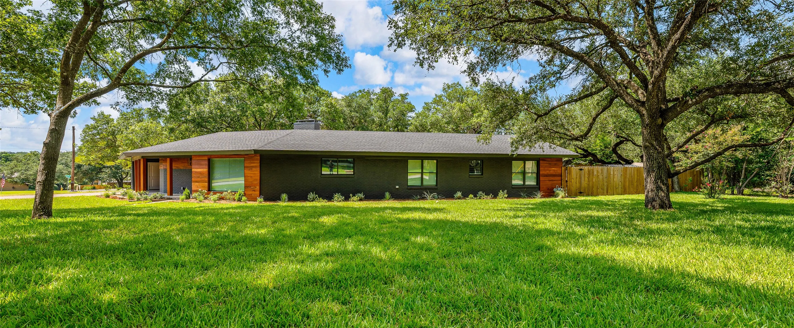 View of front of house with a chimney and view of wooded area