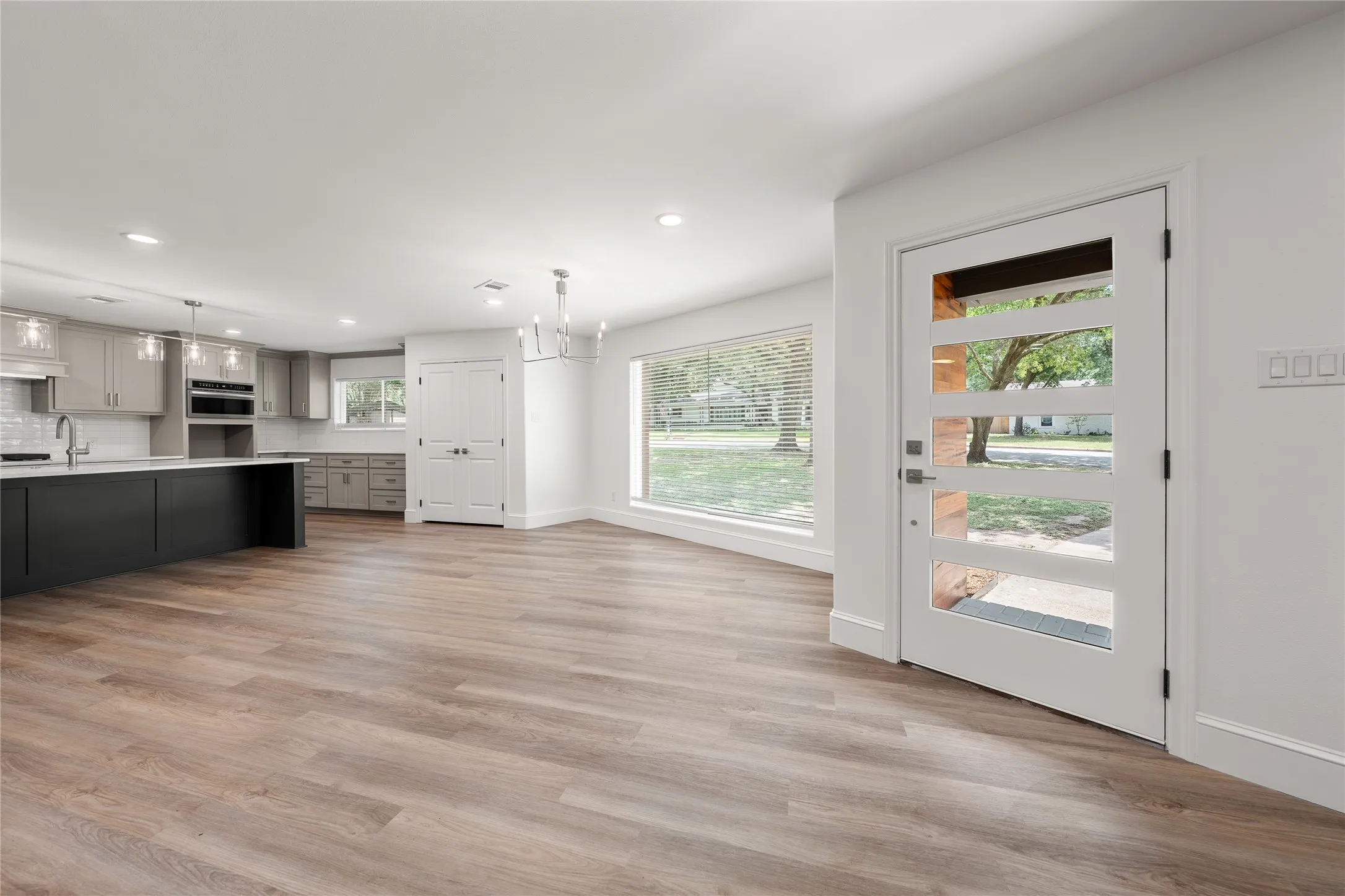 Kitchen with light countertops, gray cabinets, a chandelier, light wood finished floors, and recessed lighting