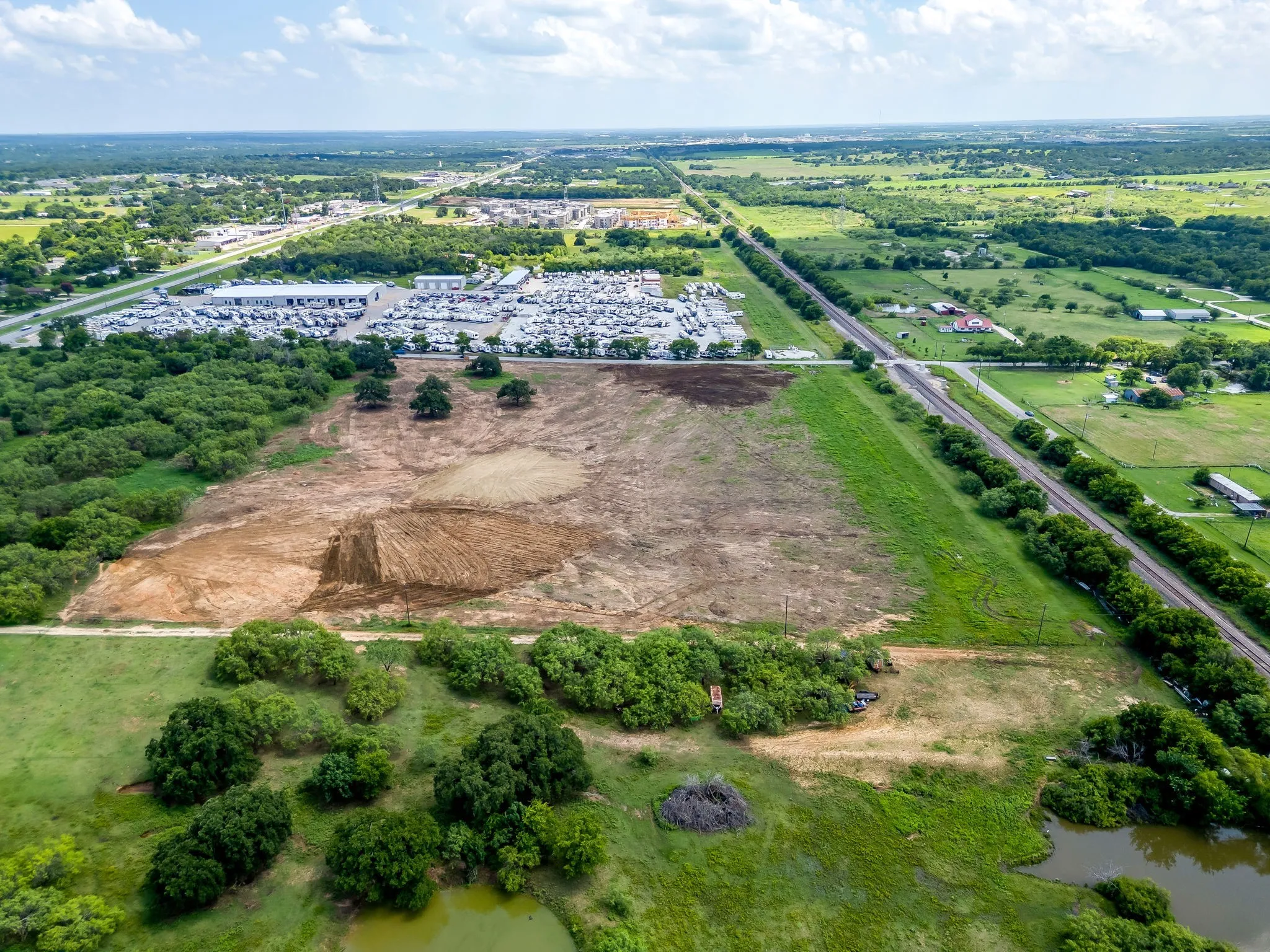 Aerial view of property and surrounding area featuring a tree filled landscape and rural landscape
