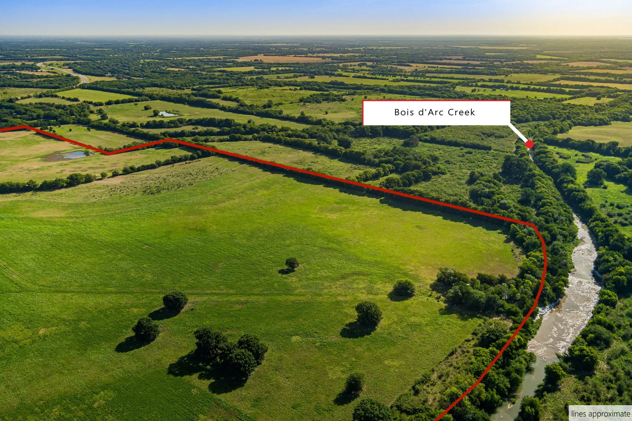 Aerial view of sparsely populated area with property parcel outlined