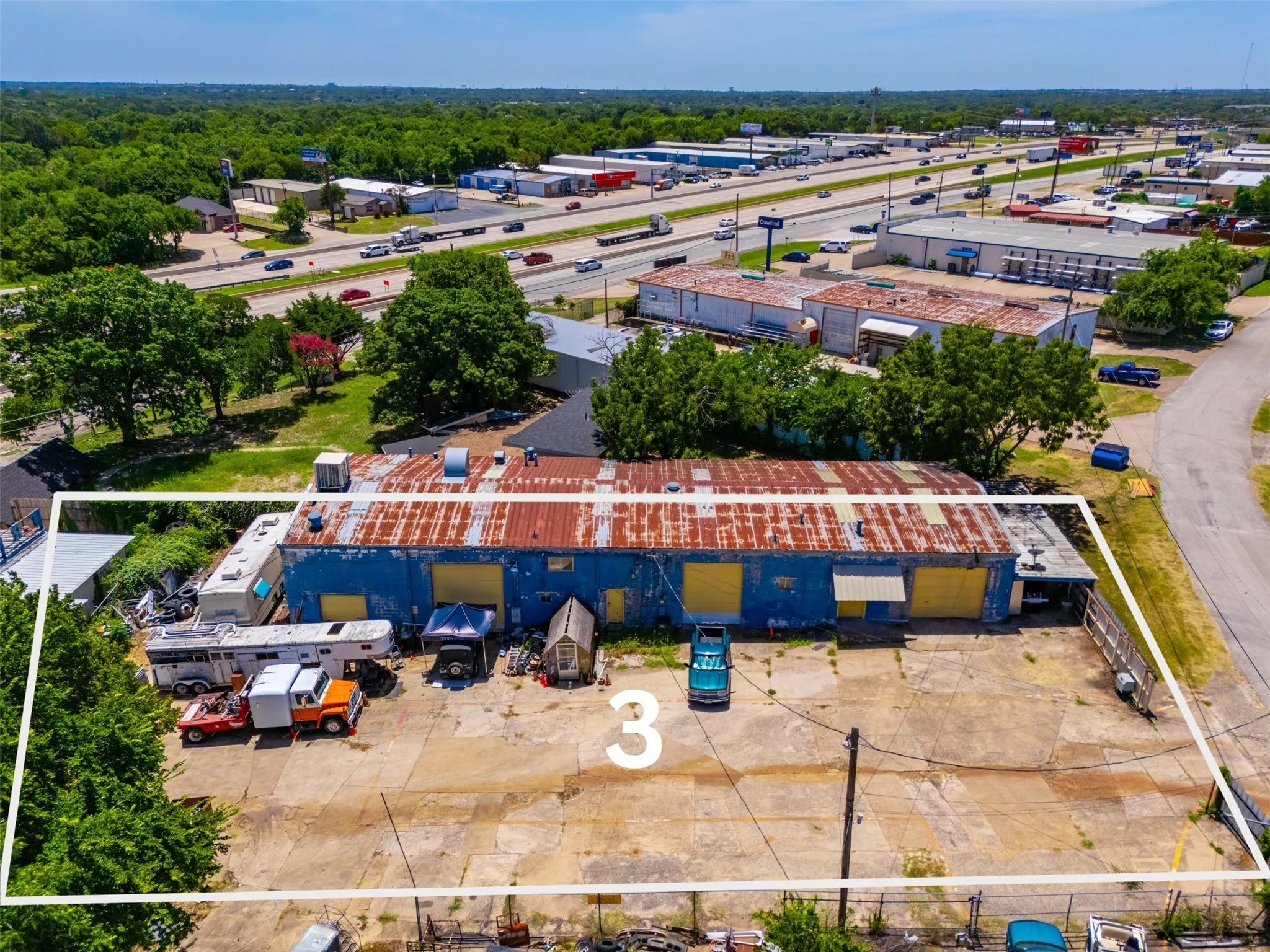 Commercial property featuring a blue-painted building with a corrugated metal roof