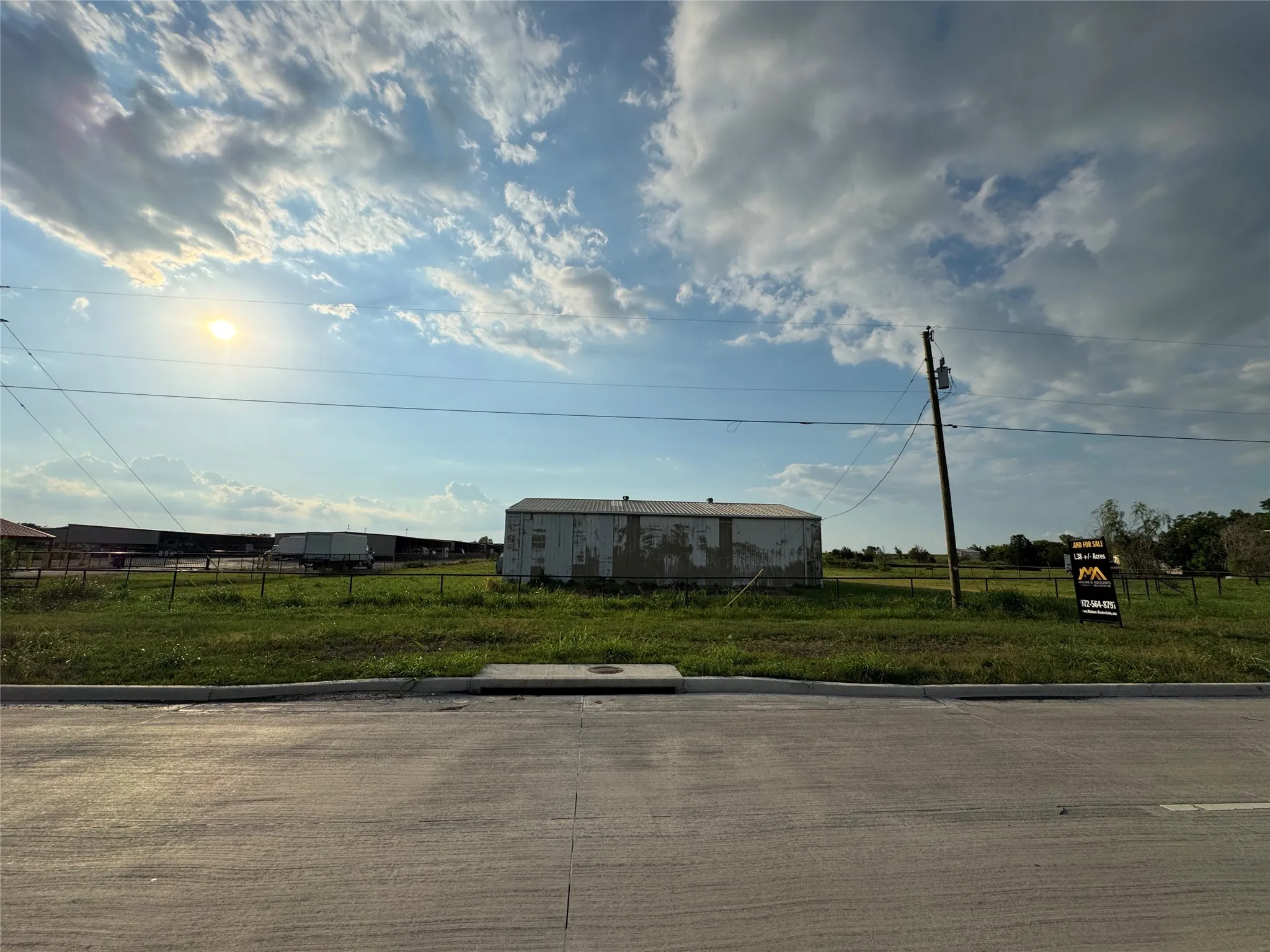View of concrete street featuring curbs and a view of rural / pastoral area