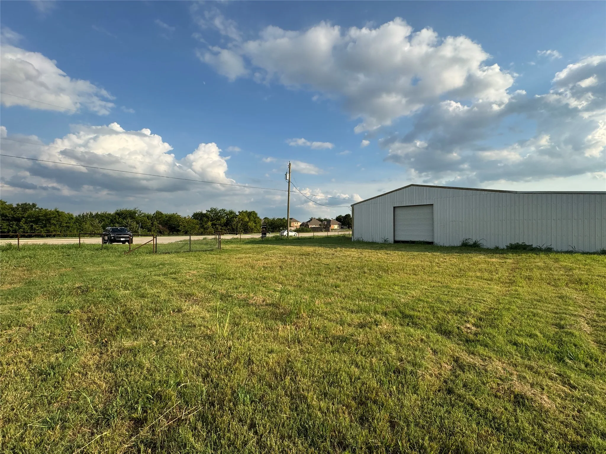 View of yard featuring an outbuilding, a pole building, and a detached garage