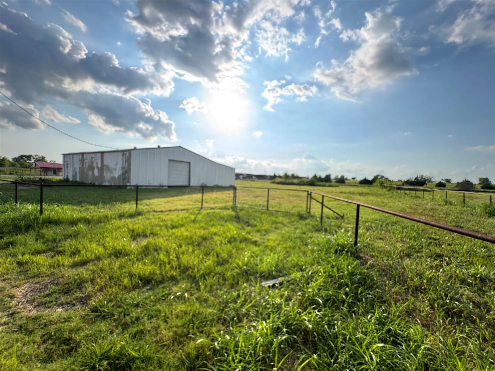 View of yard with an outbuilding, a view of rural / pastoral area, a detached garage, and an outdoor structure