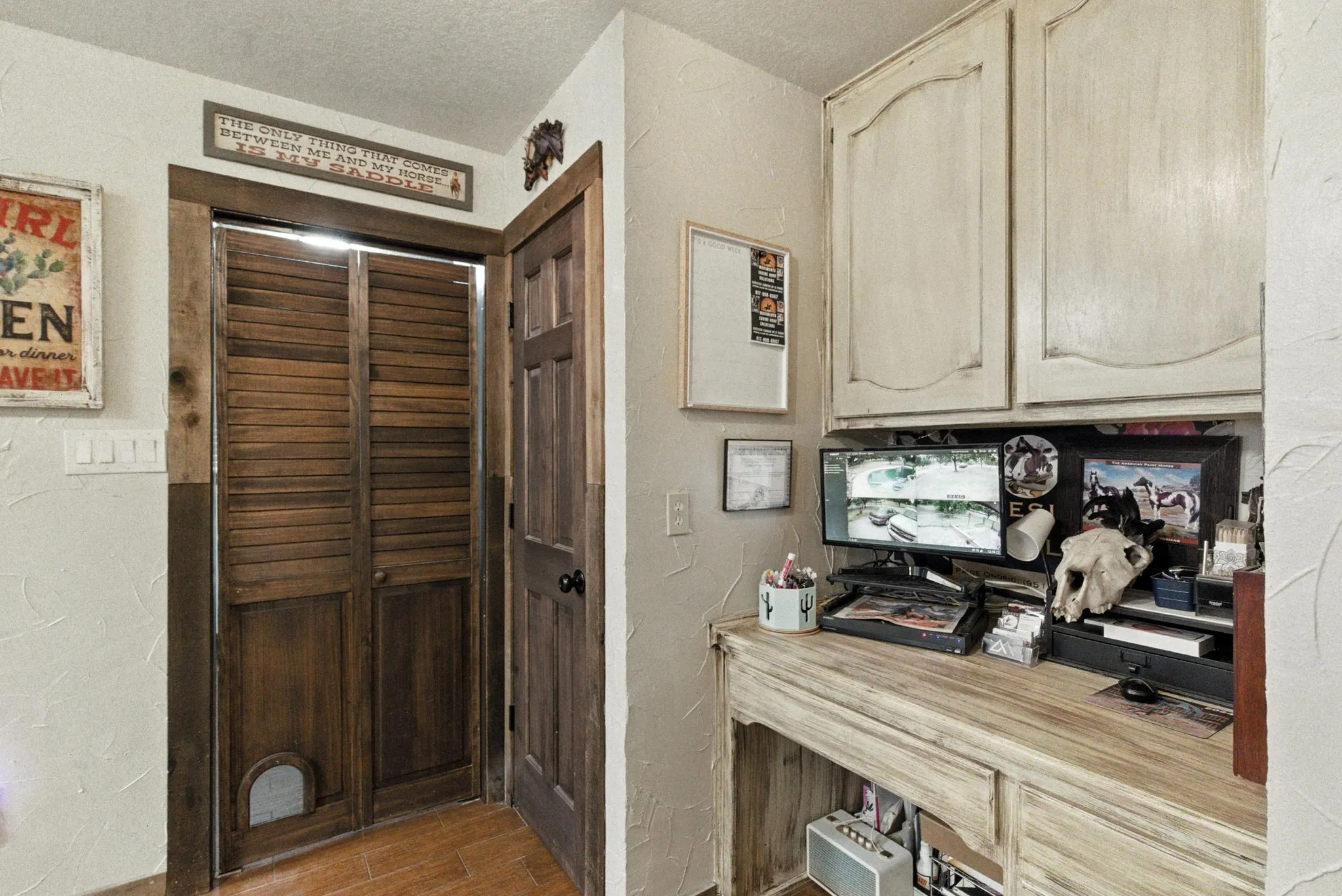 Office area featuring a textured wall, light wood-style floors, and a textured ceiling