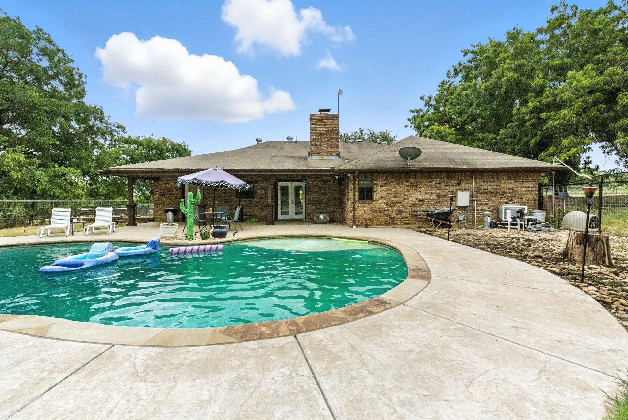 View of swimming pool with french doors and a patio area