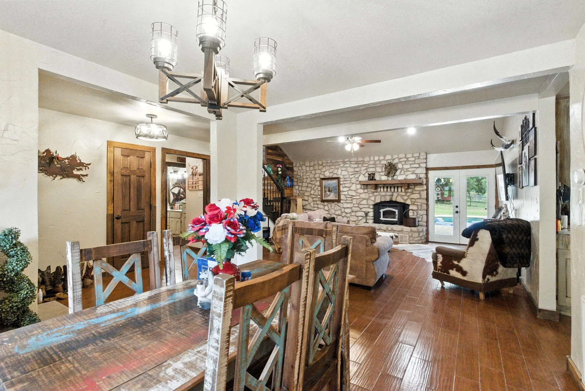 Dining room with a fireplace, dark wood-style flooring, a chandelier, and ceiling fan