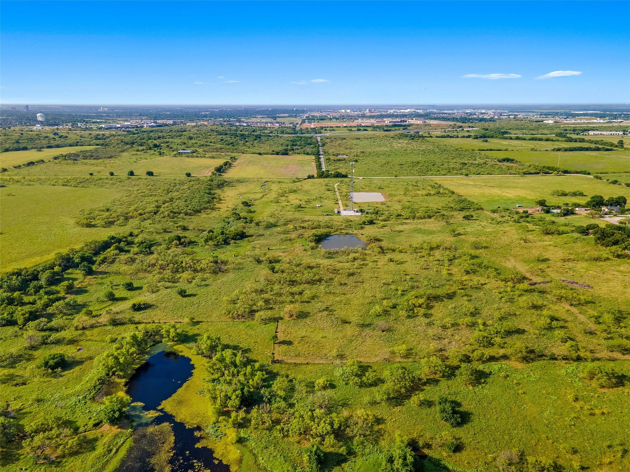 View of rural area featuring a large body of water and agricultural land