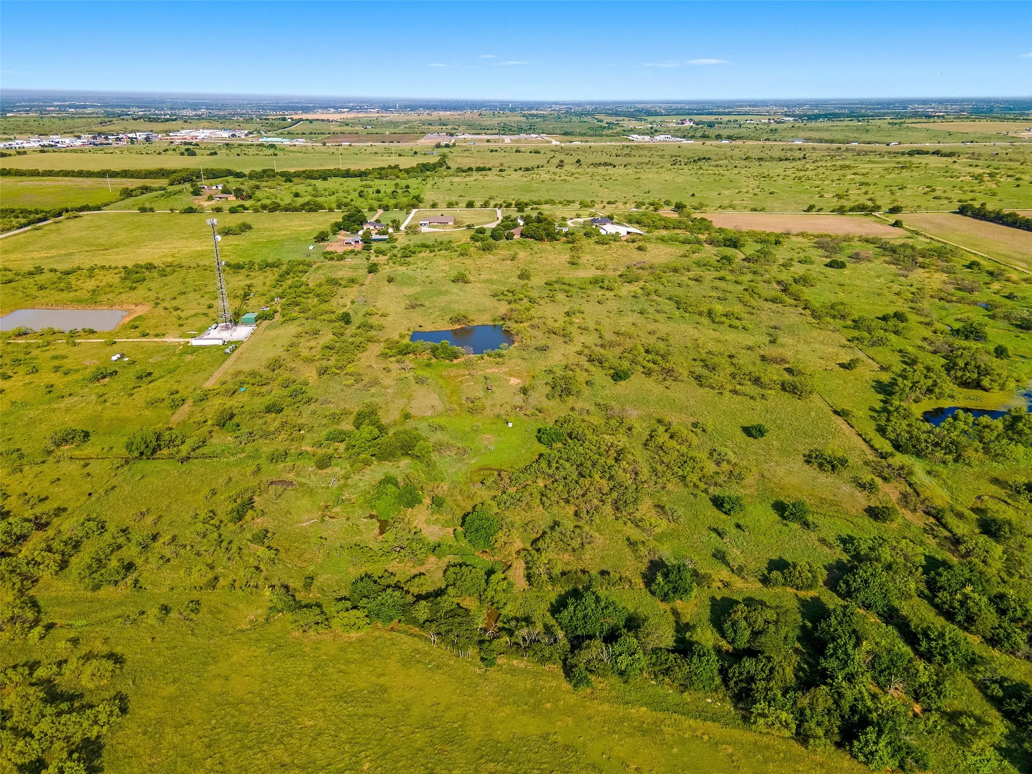Aerial view of property and surrounding area featuring a nearby body of water and rural landscape