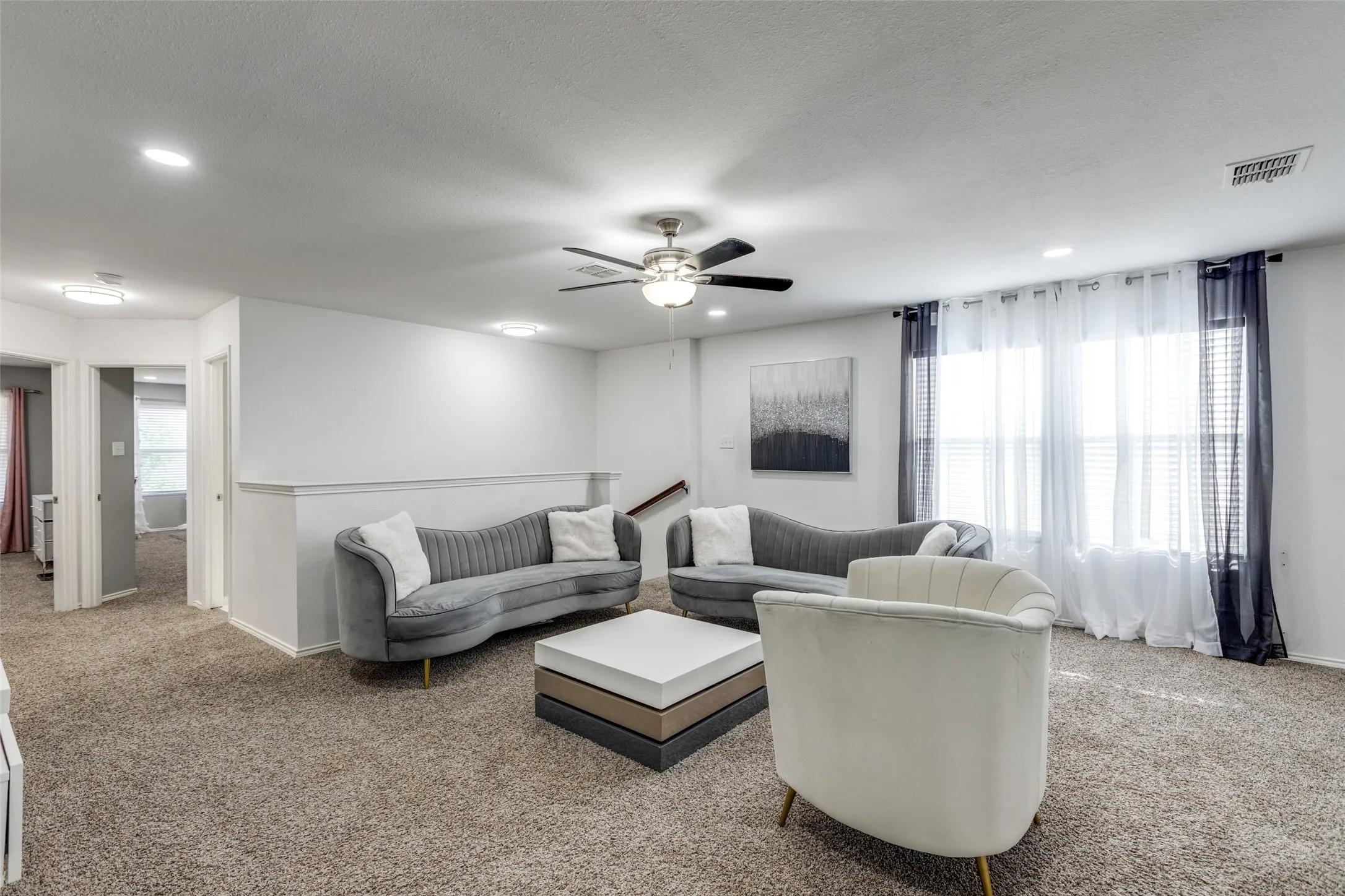Living area with carpet flooring, ceiling fan, recessed lighting, and a textured ceiling