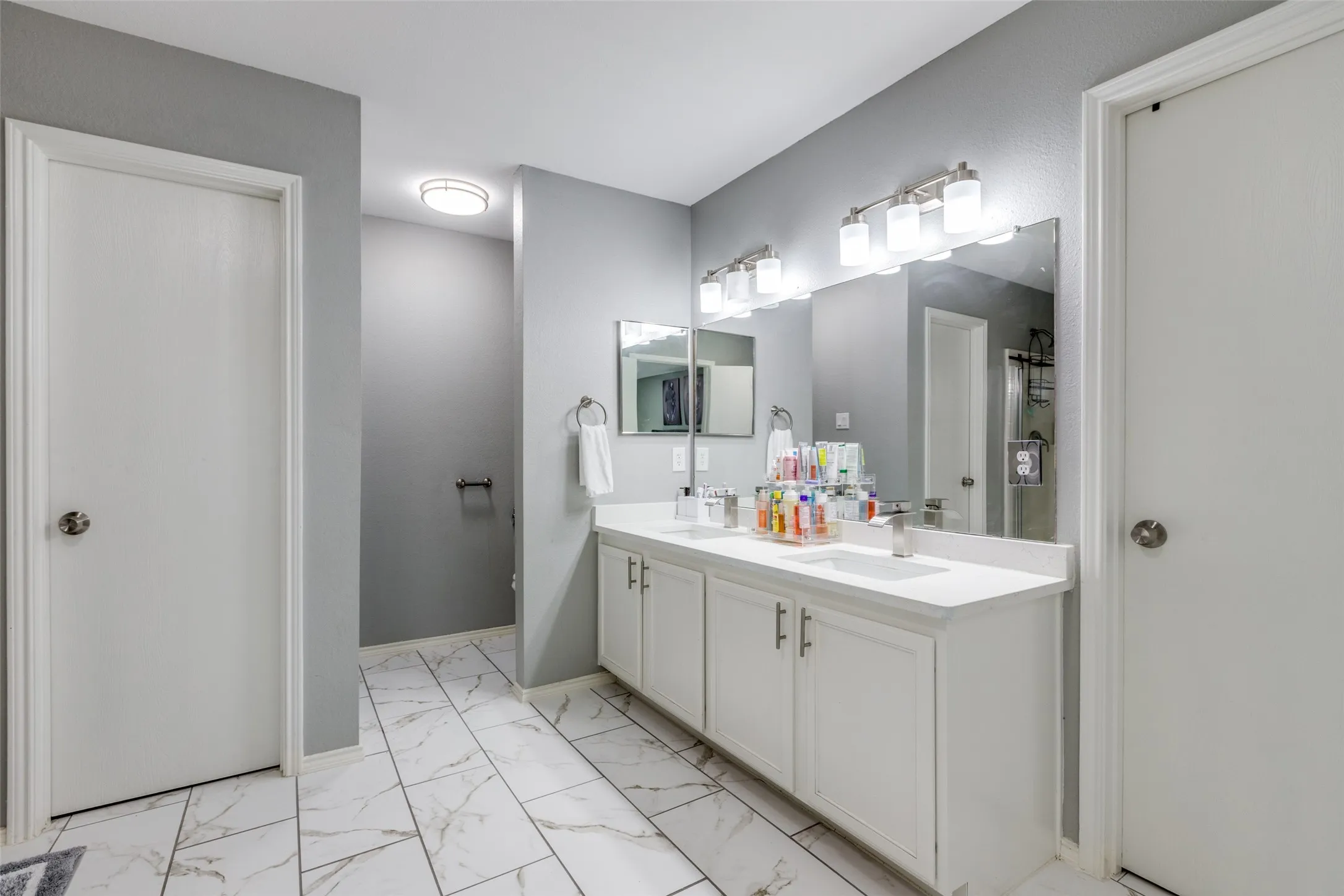 Full bathroom featuring marble look tile flooring and double vanity