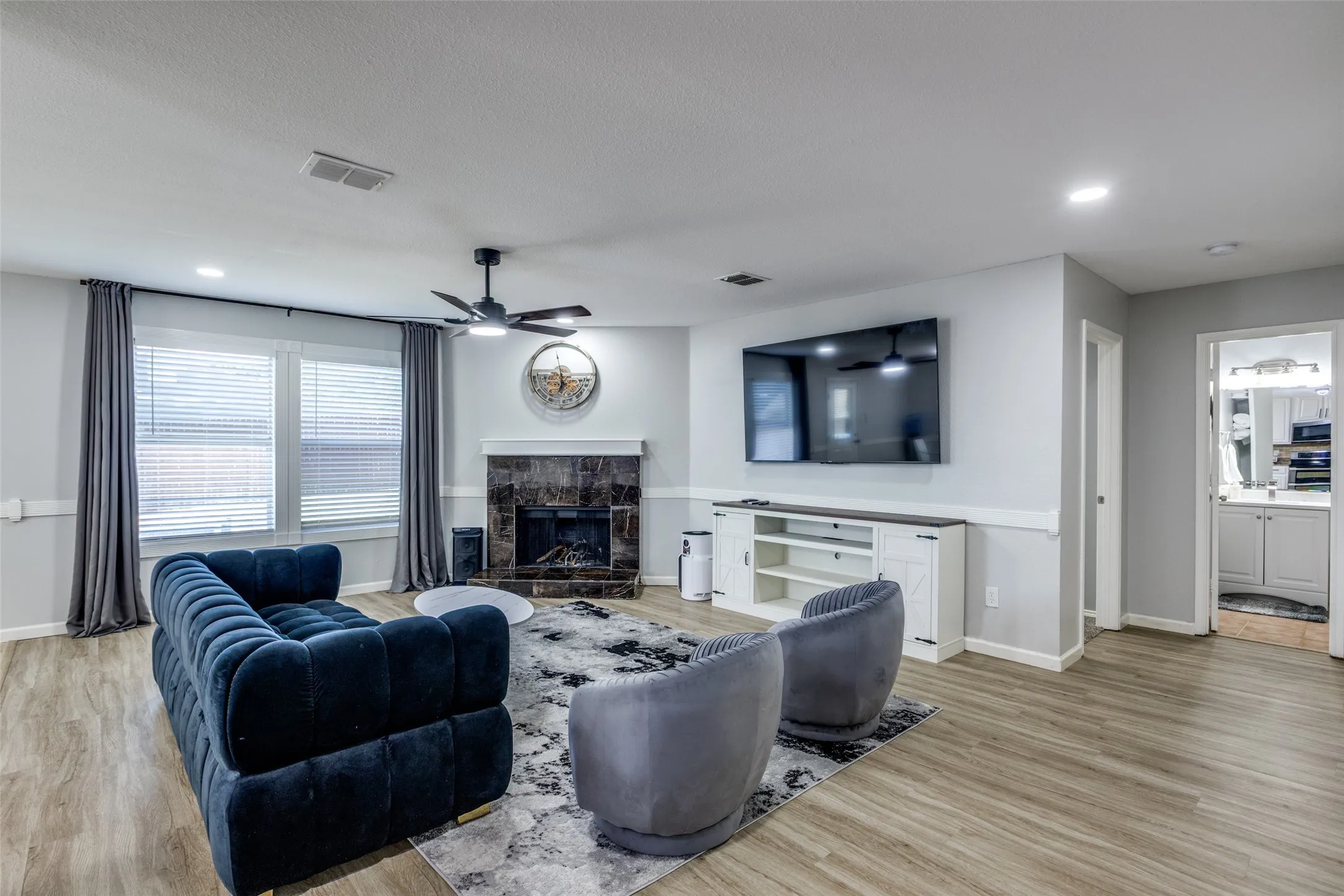 Living area featuring a fireplace, recessed lighting, light wood finished floors, and ceiling fan