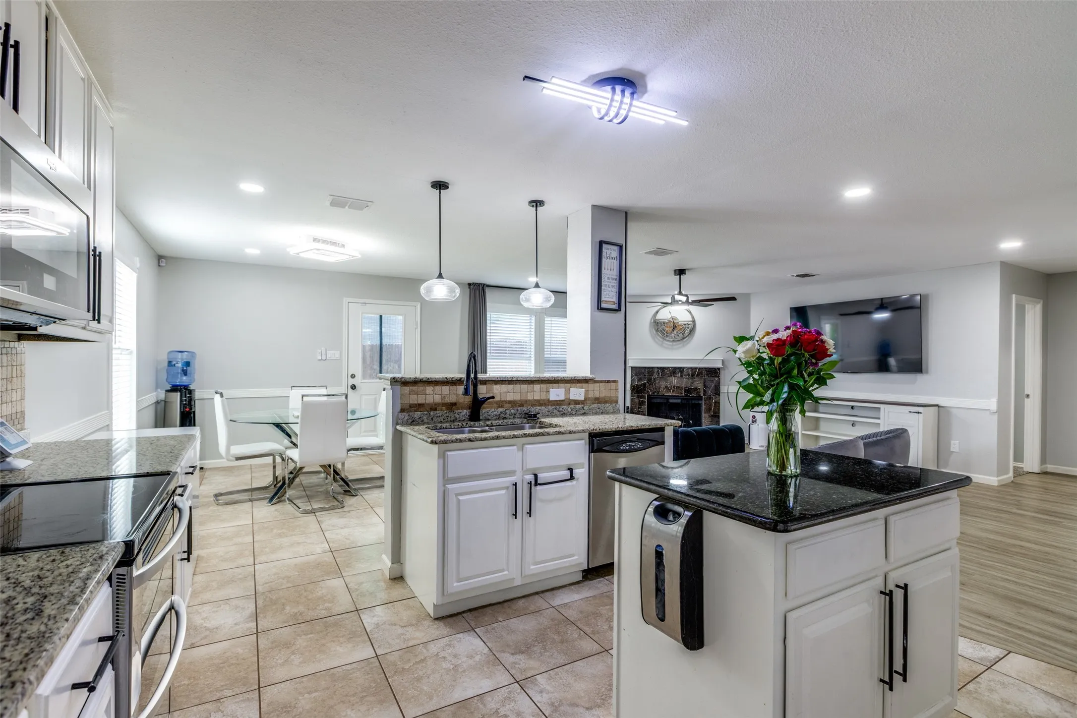 Kitchen with a kitchen island, appliances with stainless steel finishes, white cabinets, recessed lighting, and light tile patterned floors