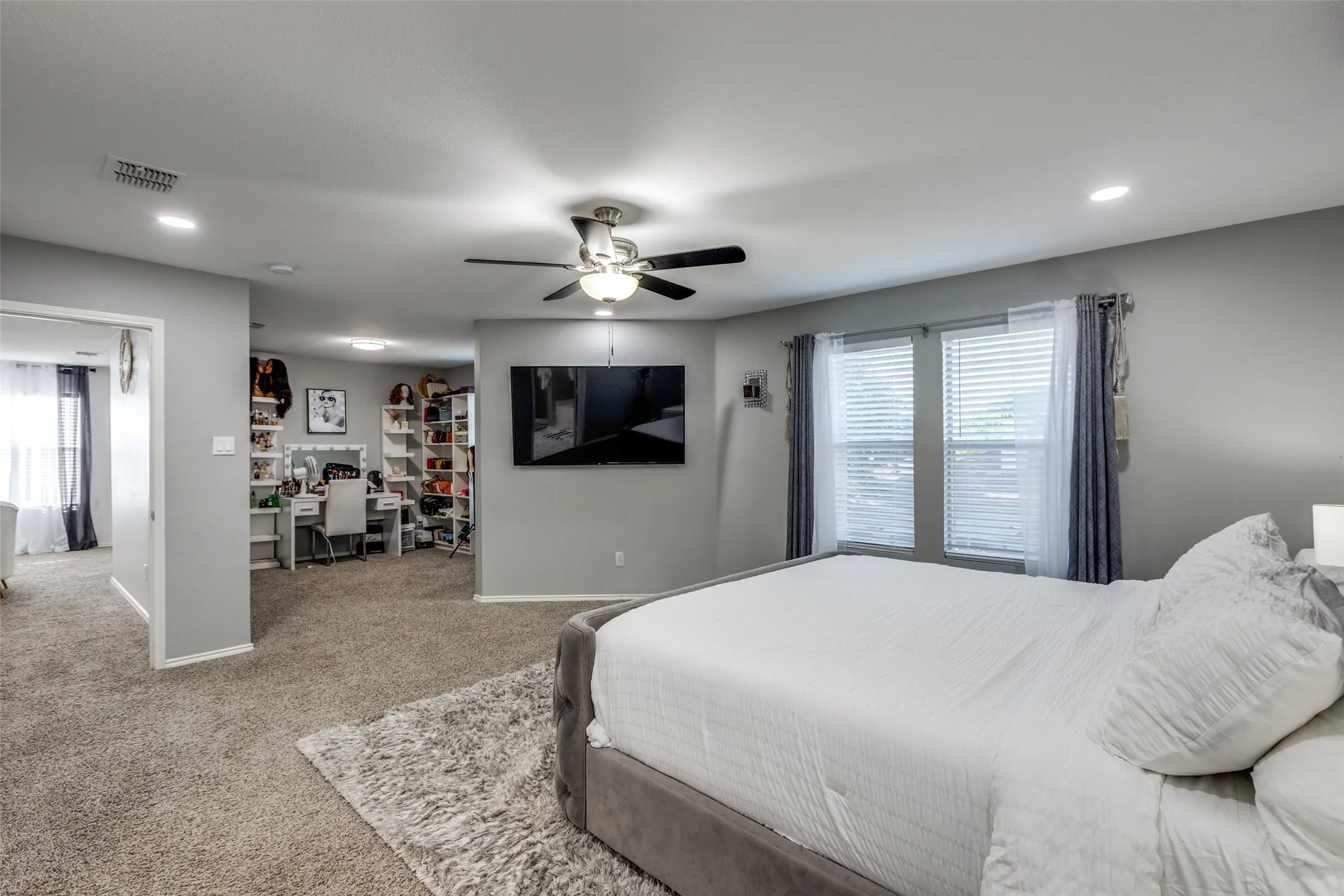 Carpeted bedroom with an office area, recessed lighting, and ceiling fan