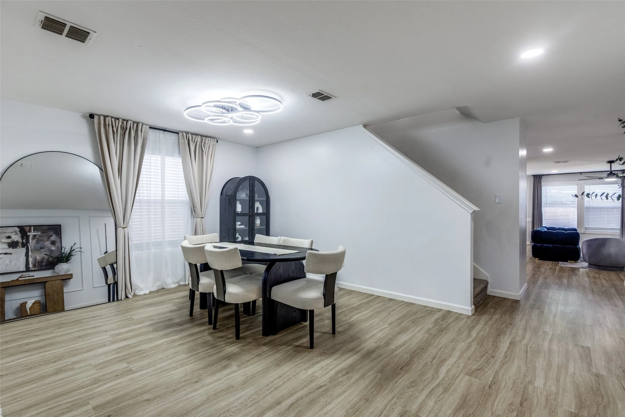 Dining space with stairs, wood finished floors, and recessed lighting