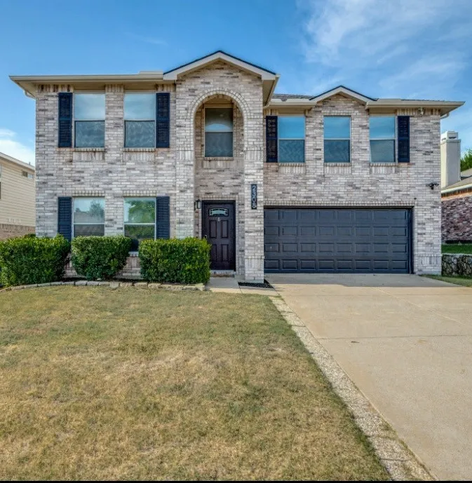 View of front of home featuring driveway, a front yard, brick siding, and an attached​​‌​​​​‌​​‌‌​‌‌​​​‌‌​‌​‌​‌​​​‌​​ garage