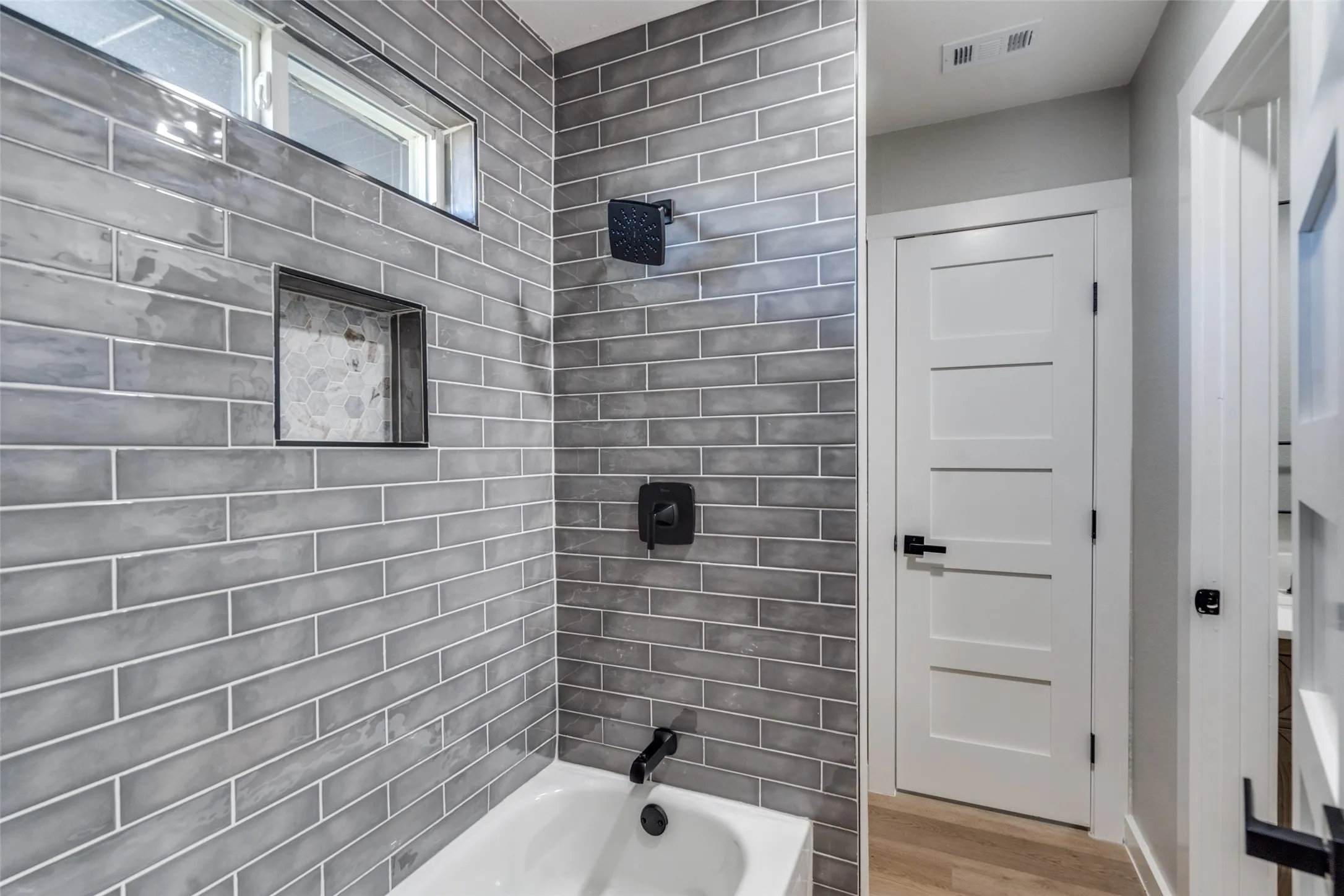 Full bathroom featuring wood finished floors and shower / bath combination