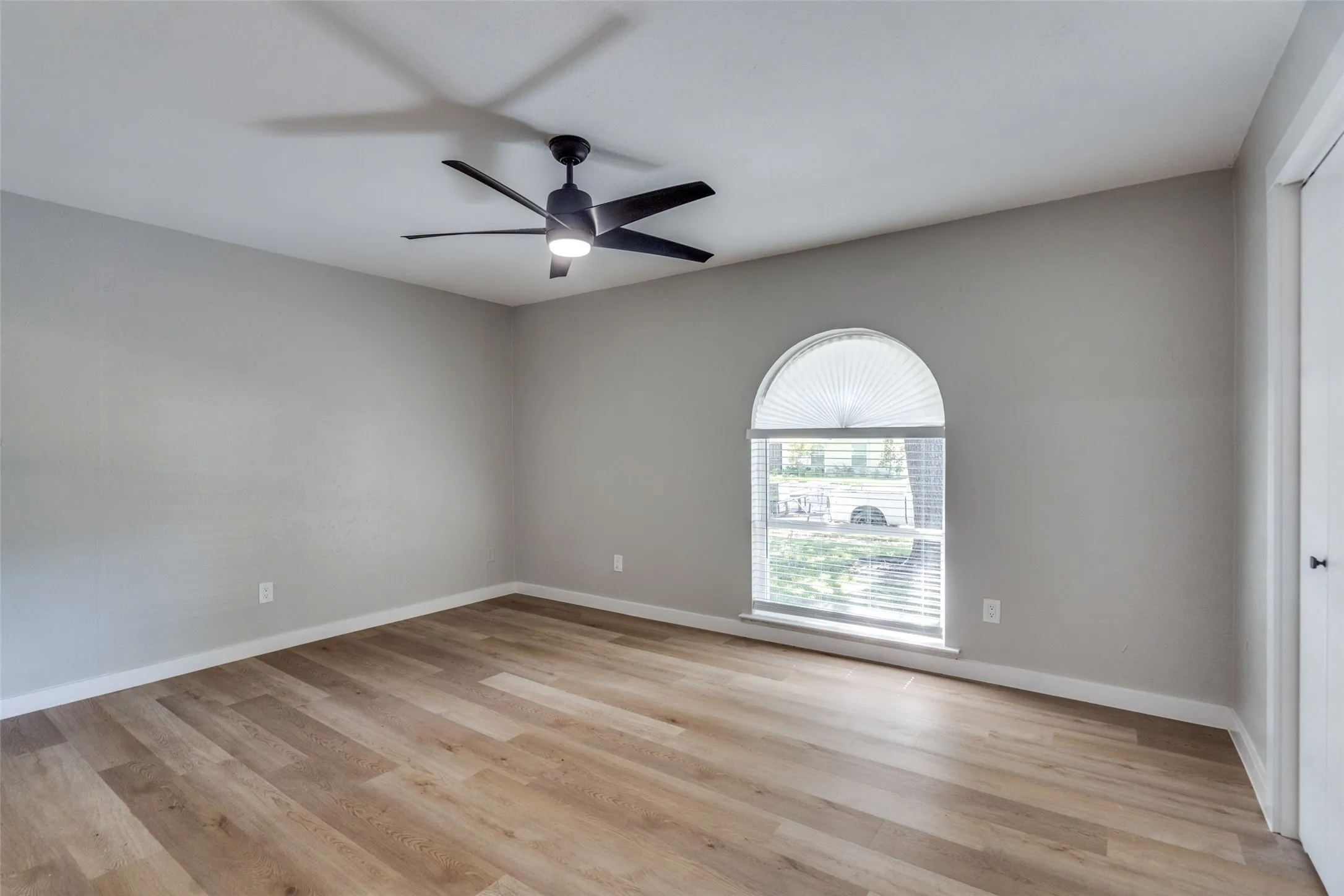 Empty room featuring light wood-style flooring and a ceiling fan