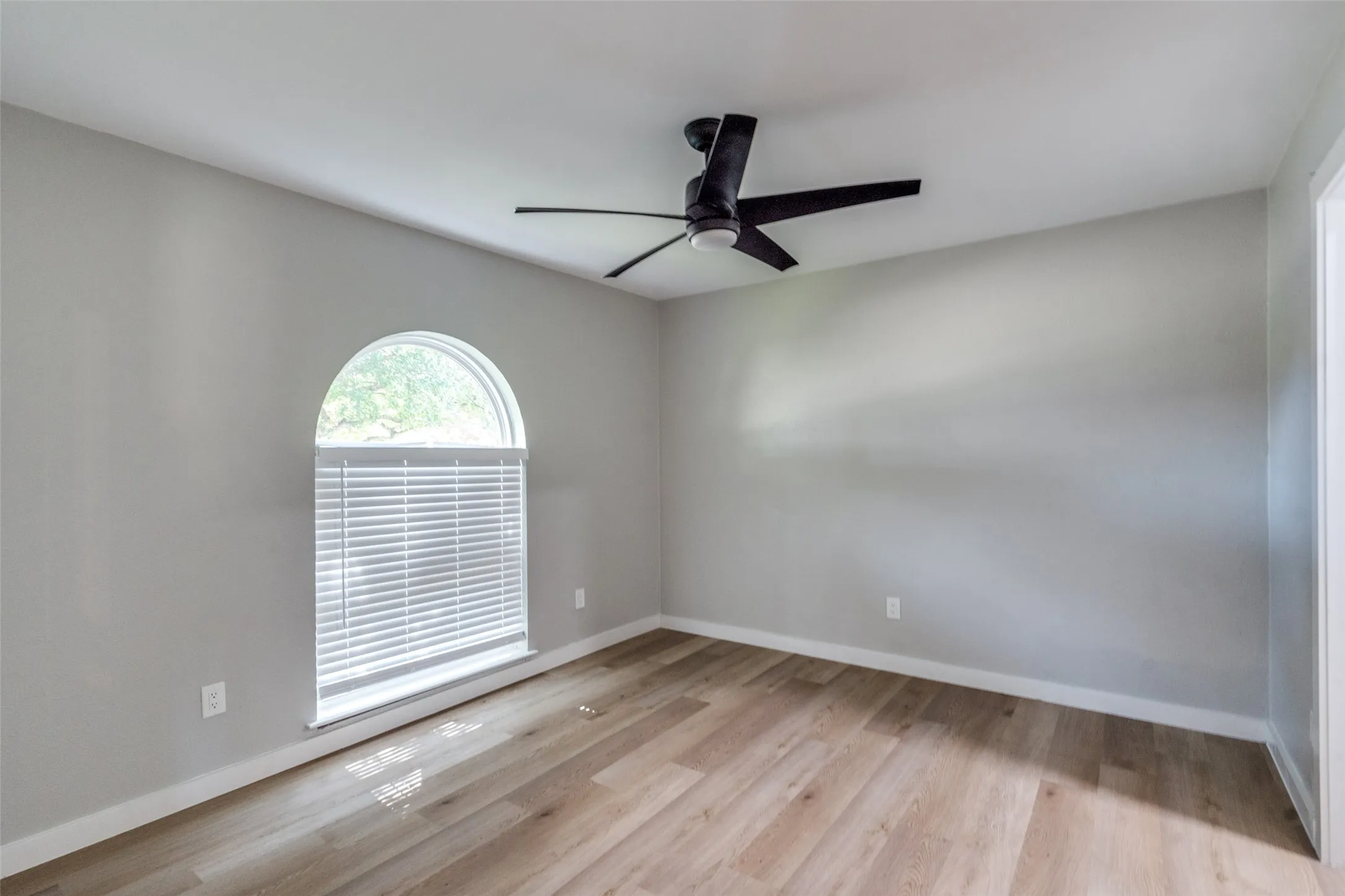 Empty room featuring wood finished floors and a ceiling fan