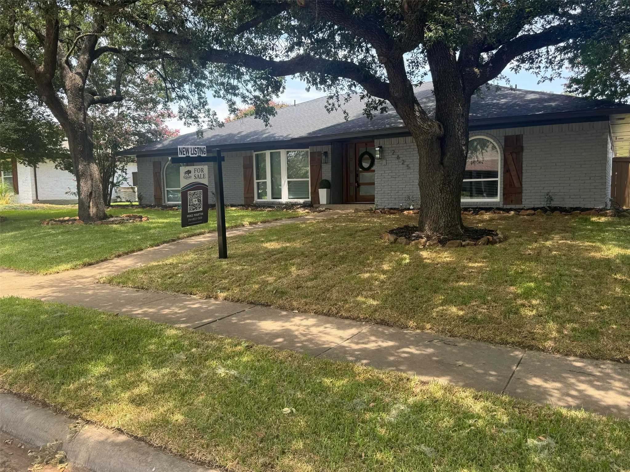 Ranch-style home with a front yard and brick siding