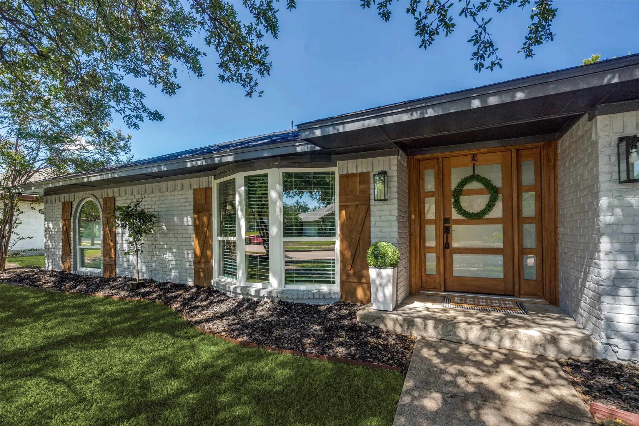 Entrance to property featuring brick siding and a lawn