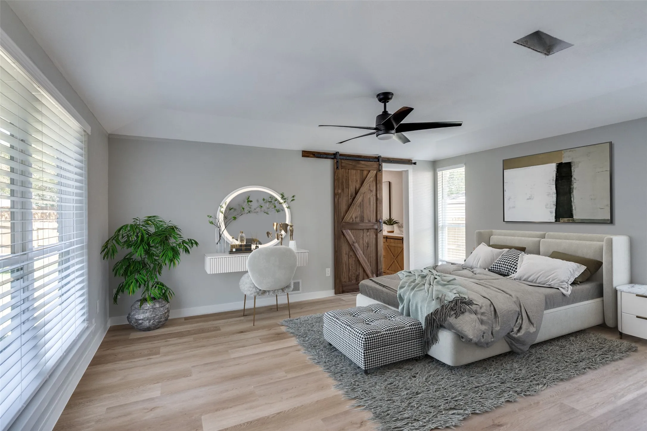 Bedroom featuring a barn door, light wood-style flooring, and a ceiling fan