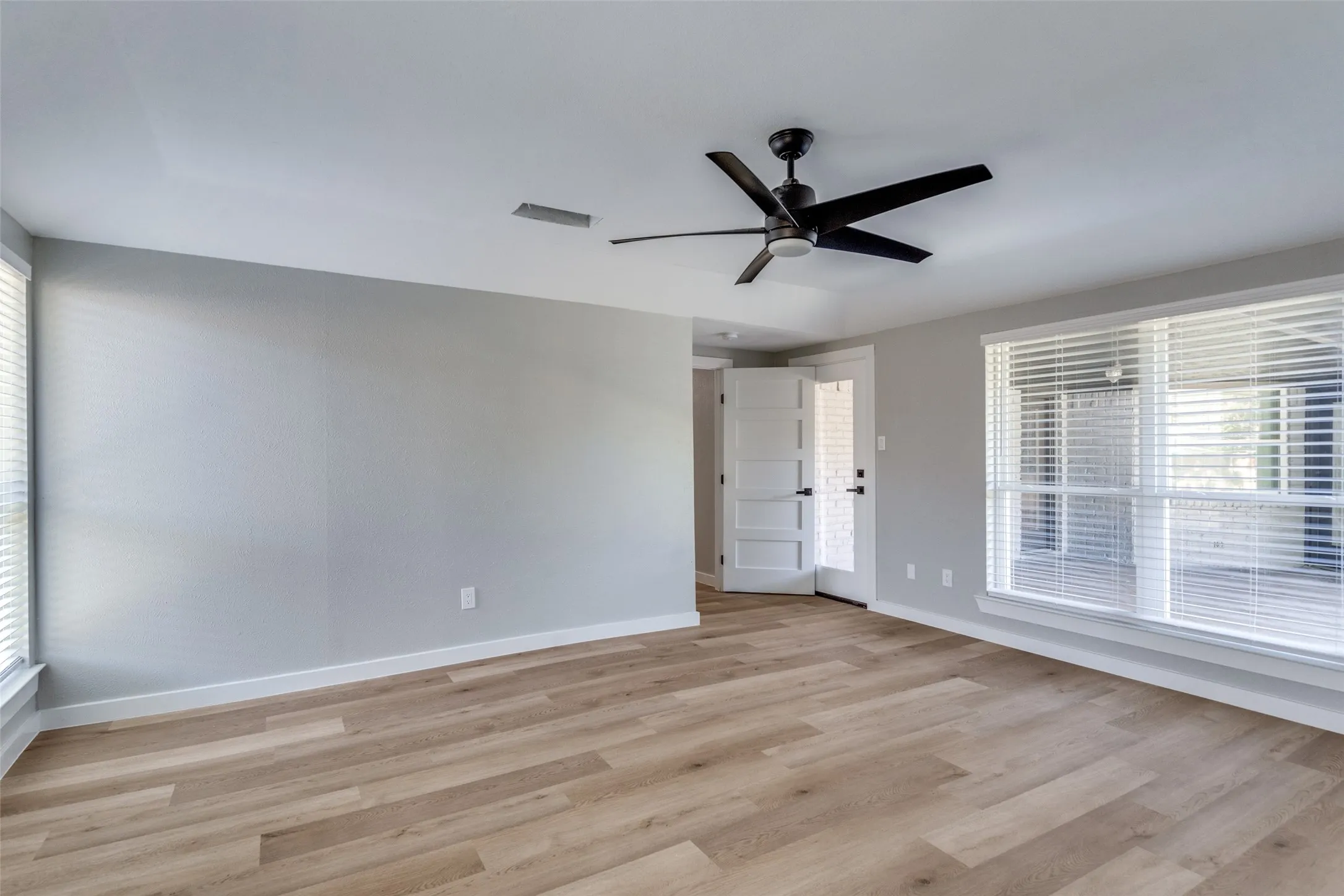 Unfurnished room featuring light wood-type flooring and ceiling fan