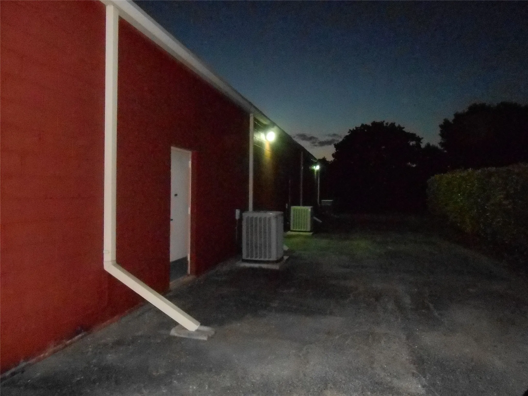 Property exterior at twilight featuring a cooling unit