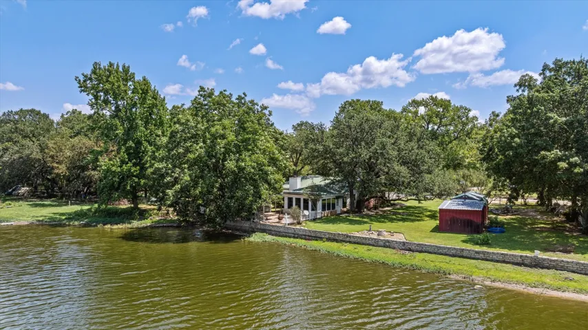Waterfront retreat offers stone retaining wall, gazebo with hot tub, koi fountain and retractable awning on lakeside patio. Waiting to welcome you home 246 Comanche Trail, Weatherford TX 76087